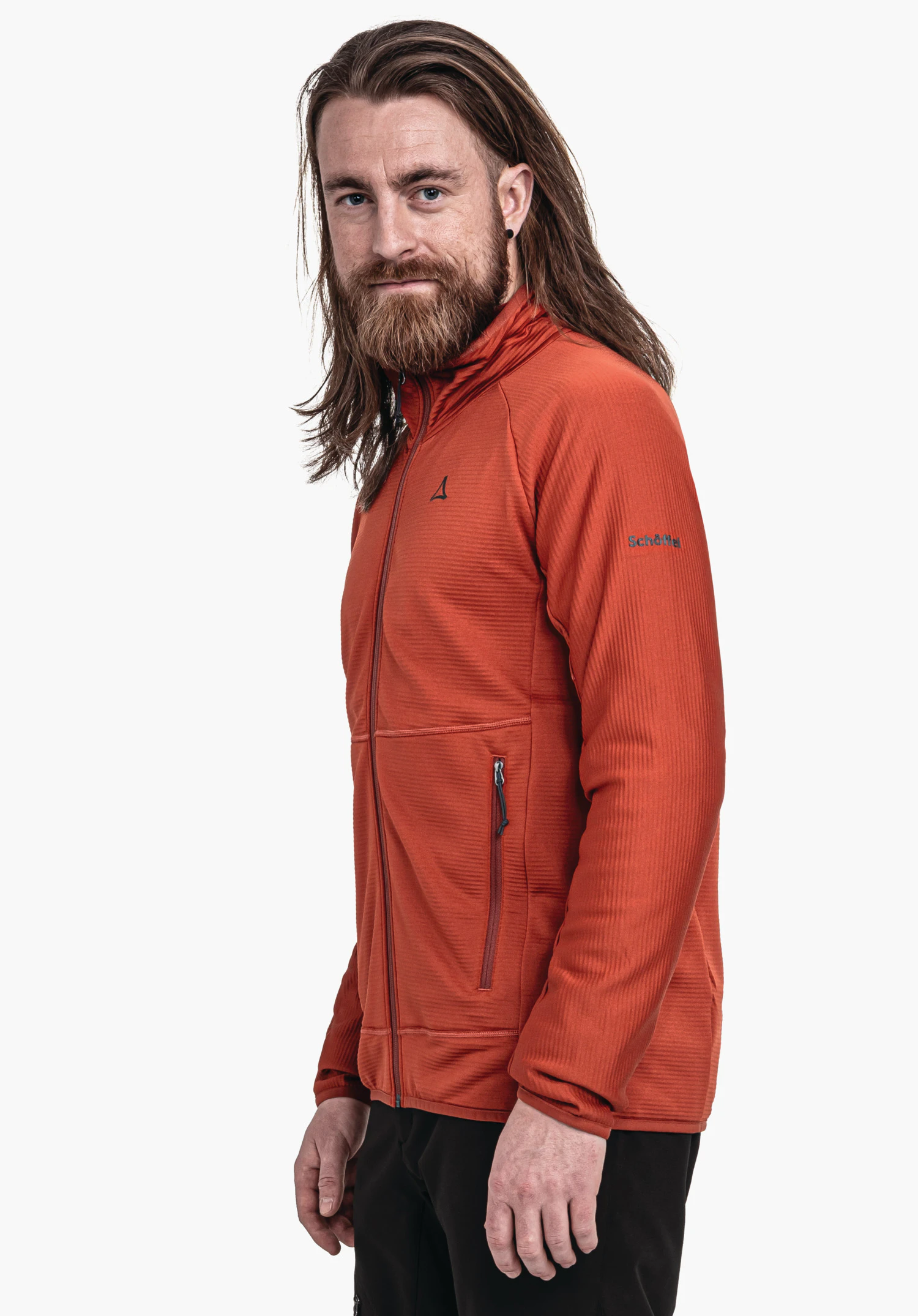 Fleece Jk Style Cascata MNS Dunkelrot Fleecejacke an stehendem Mann; Jacke trägt Schöffel-Logo auf Brust und Schriftzug "Schöffel" am Ärmel. Mann mit langen braunen Haaren, hellblaue Augen, weißer Hintergrund.