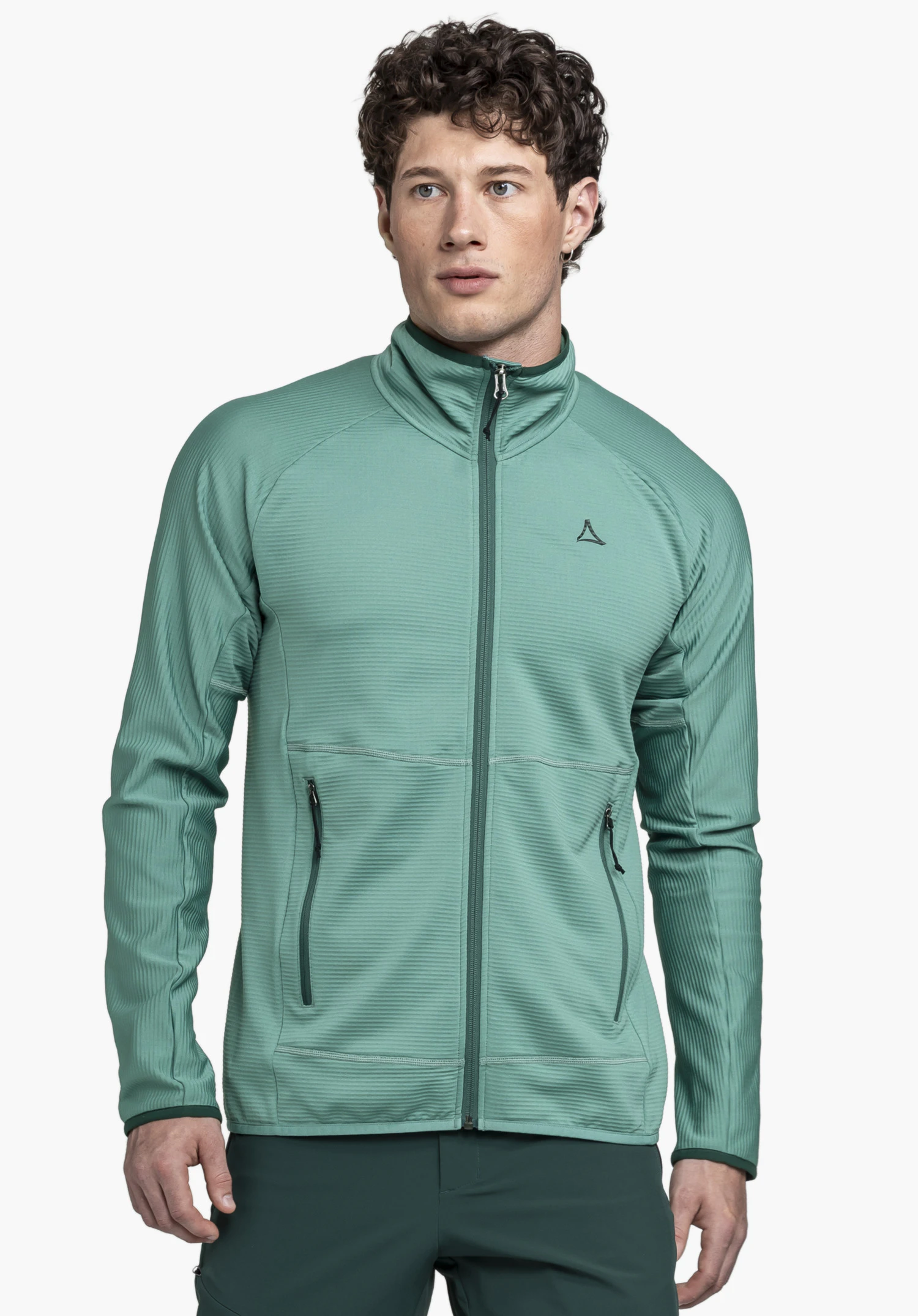 Fleece Jk Style Cascata MNS. Un mannequin se tient de face et porte la veste en polaire verte, qui se caractérise par une fermeture éclair, deux poches latérales et le logo Schöffel sur la poitrine gauche. La vue portée est présentée devant un fond neutre.
