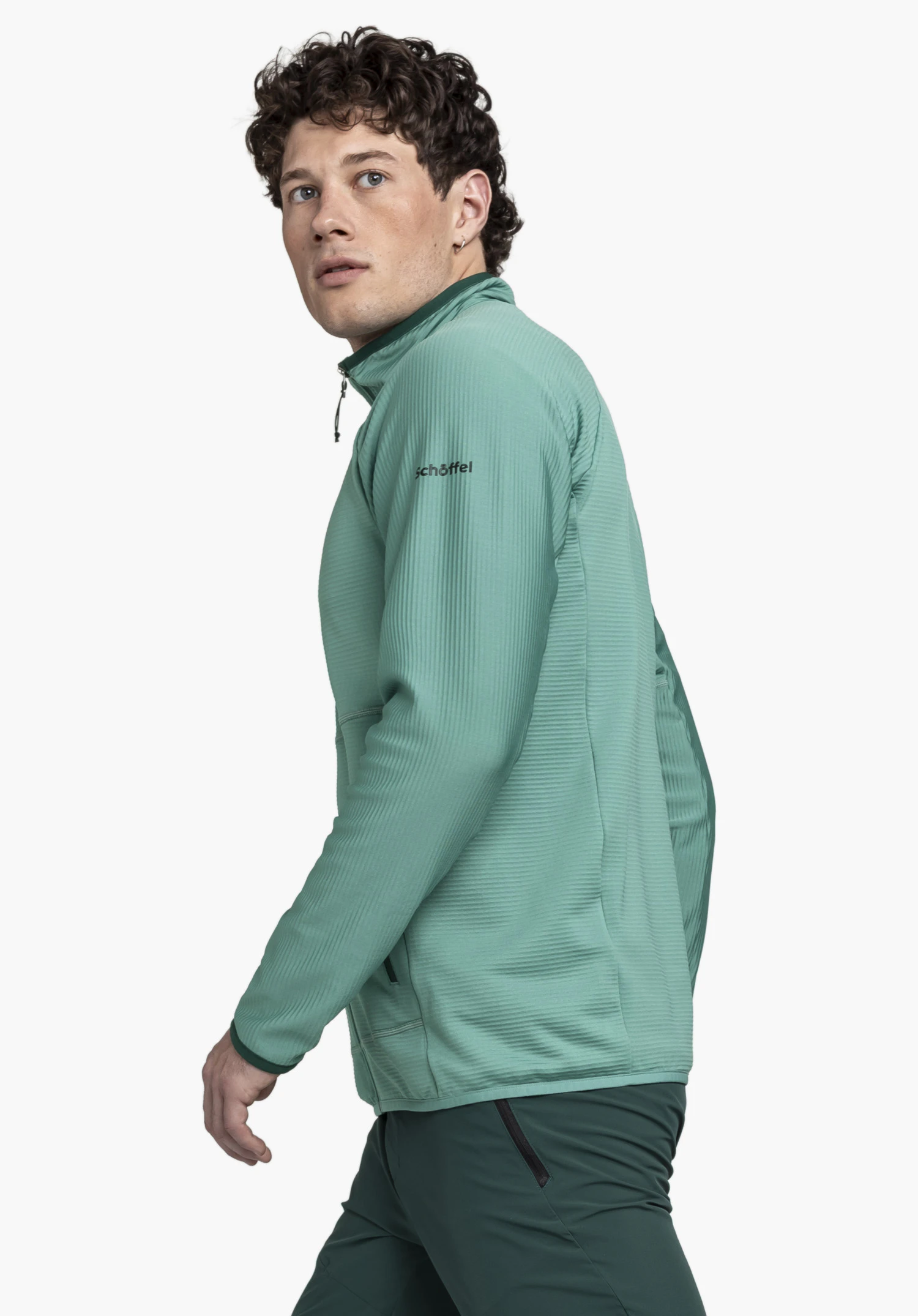 Fleece Jk Style Cascata MNS en vert : Le mannequin est présenté de profil sur un fond neutre. La veste polaire arbore une teinte verte fraîche, tandis que le logo Schöffel est visible de manière discrète sur la poitrine.
