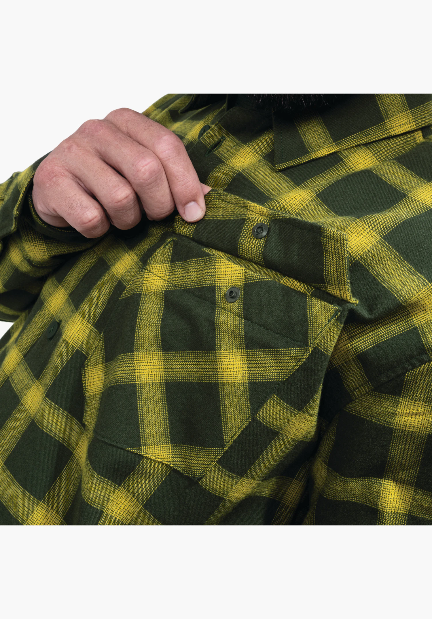 Shirt Style Poplar MNS, Detailansicht der Brusttasche mit geknöpfter Patte im gelben Karomuster, die von einer Hand angehoben wird. Nahaufnahme vor neutralem Hintergrund.
