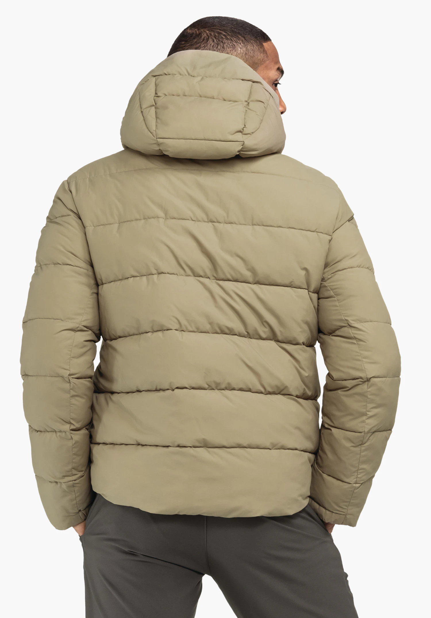 Ins Jacket Style Lodos MNS Hellgrüne Steppjacke, von einer Person von hinten getragen; steht mit Händen in den Taschen, Kapuze hochgeklappt, neutraler weißer Hintergrund.
