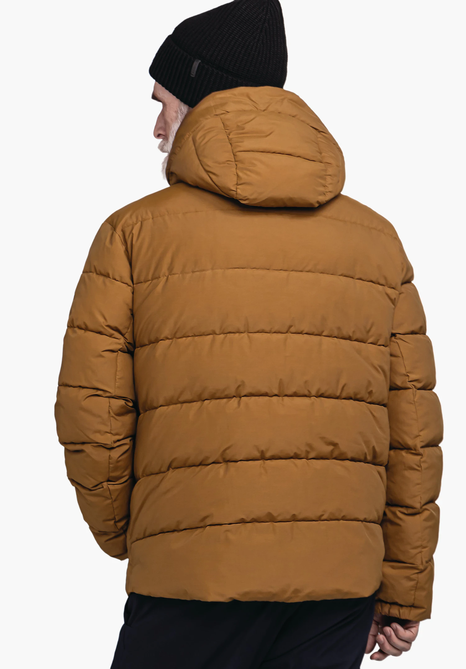 Ins Jacket Style Lodos MNS donkeroranje gewatteerde jas met capuchon, van achteren gedragen door een man; handen ontspannen langs het lichaam, zwarte beanie, donkerblauwe broek, witte studioachtergrond.