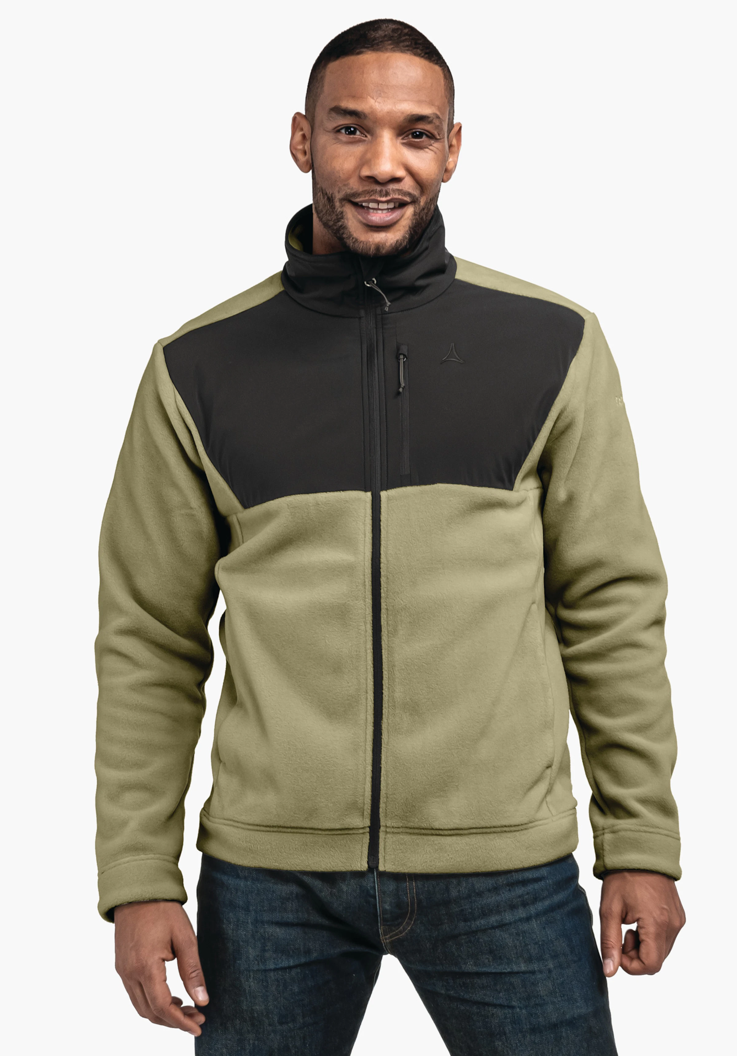 Fleece Jk Style Gregale MNS Veste polaire vert clair avec empiècements poitrine et col noirs, logo Schöffel visible, portée par un homme debout souriant; jean bleu, fond studio blanc.