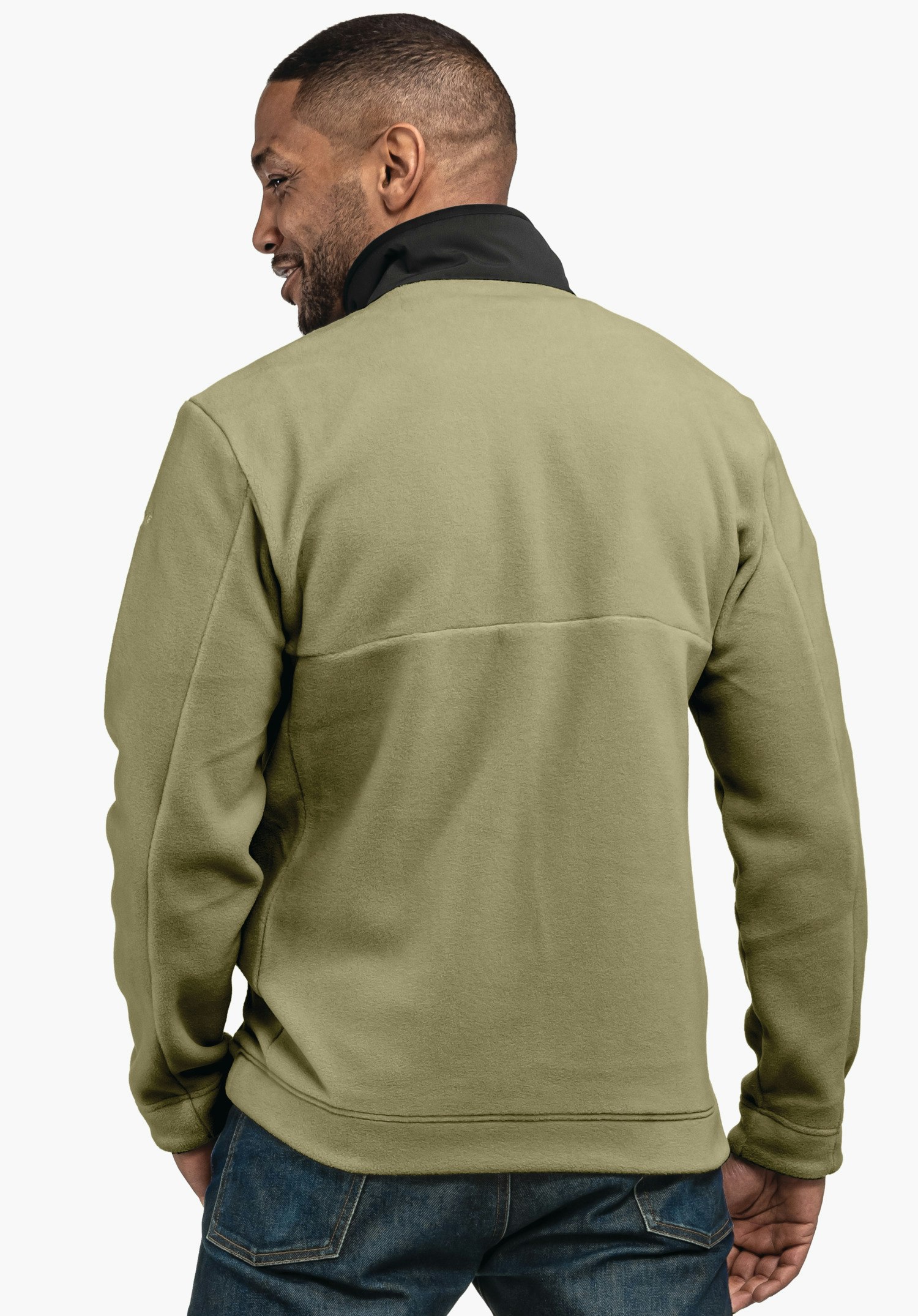 Fleece Jk Style Gregale MNS hellgrüne Fleecejacke mit schwarzem Stehkragen, getragen von einem Mann, steht mit dem Rücken zum Betrachter und Blick nach links; dunkelblaue Jeans; weißer Hintergrund.