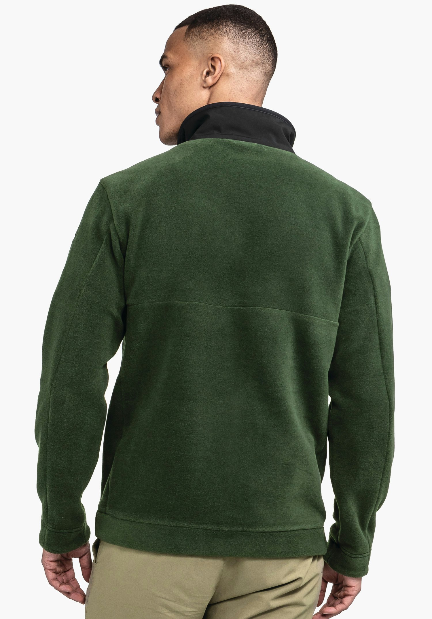 Fleece Jk Style Gregale MNS dunkelgrüne Fleecejacke, Mann trägt sie und steht halbgedreht, mit sichtbarem schwarzen Stehkragen; Hände locker an den Seiten, neutraler weißer Hintergrund.