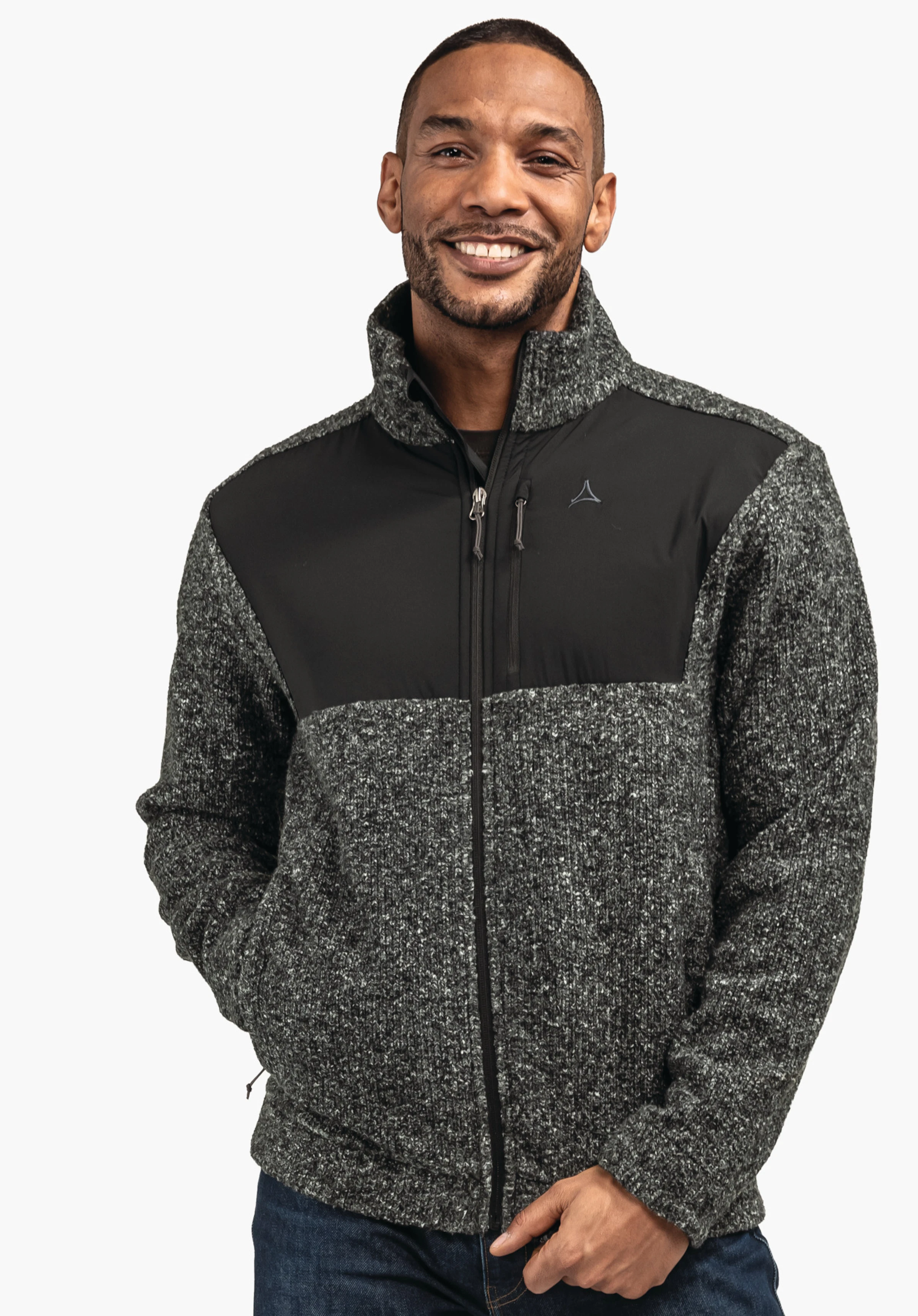 Fleece Jk Style Canterbury MNS Jacke: dunkelgrauer, melierter Strick mit schwarzem Brustpanel und Reißverschluss, Schöffel-Logo links auf der Brust, getragen von lächelndem Mann vor weißem Hintergrund.