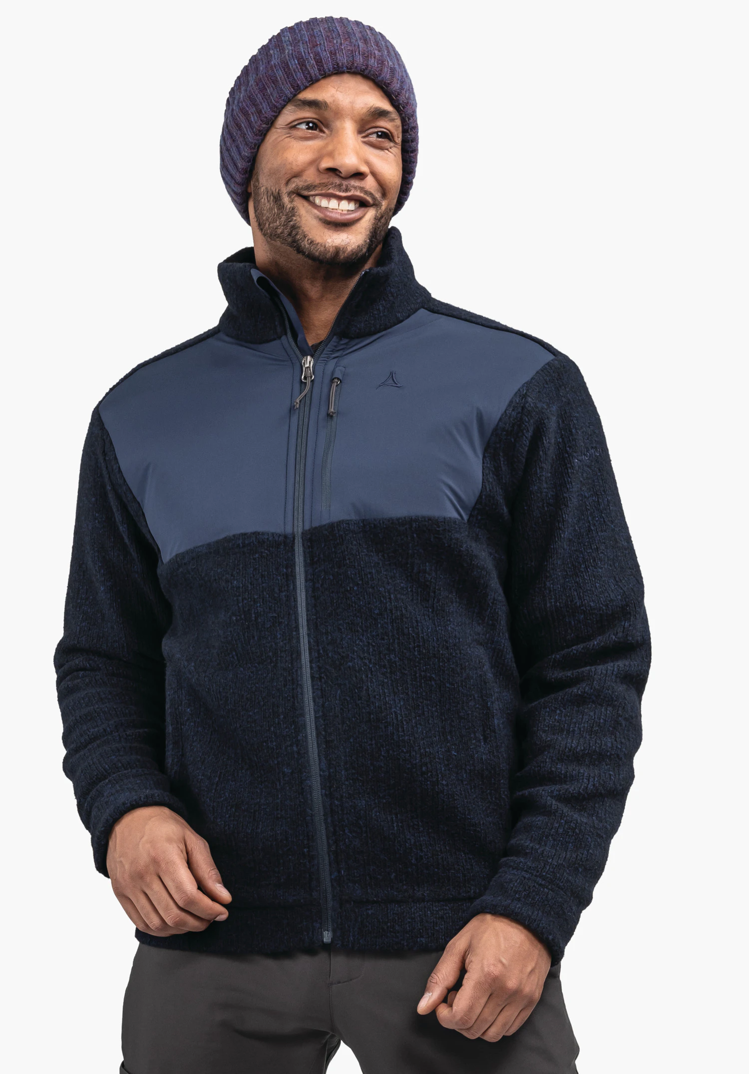 Fleece Jk Style Canterbury MNS dark blue fleece jacket with light blue chest panel, zipped at the front, Schöffel logo on the chest; worn by a smiling person wearing a dark purple beanie against a neutral background.