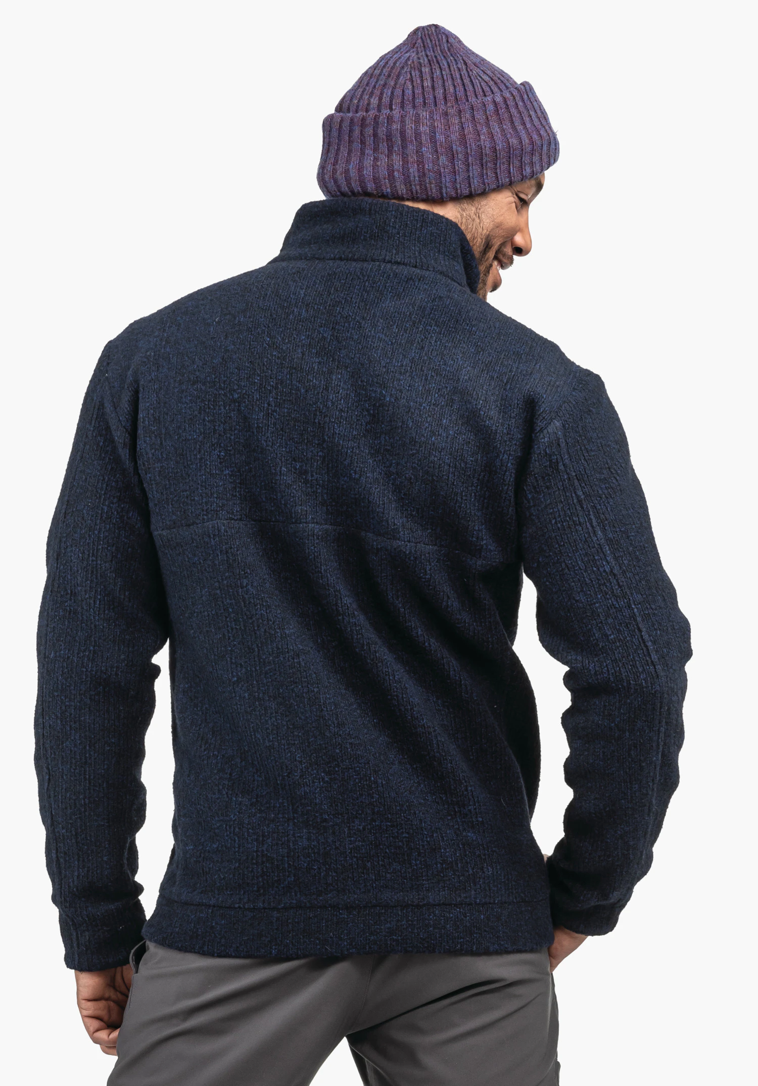 Fleece Jk Style Canterbury MNS dark blue knitted jacket worn by a man from the back; purple beanie and grey trousers; light neutral background.