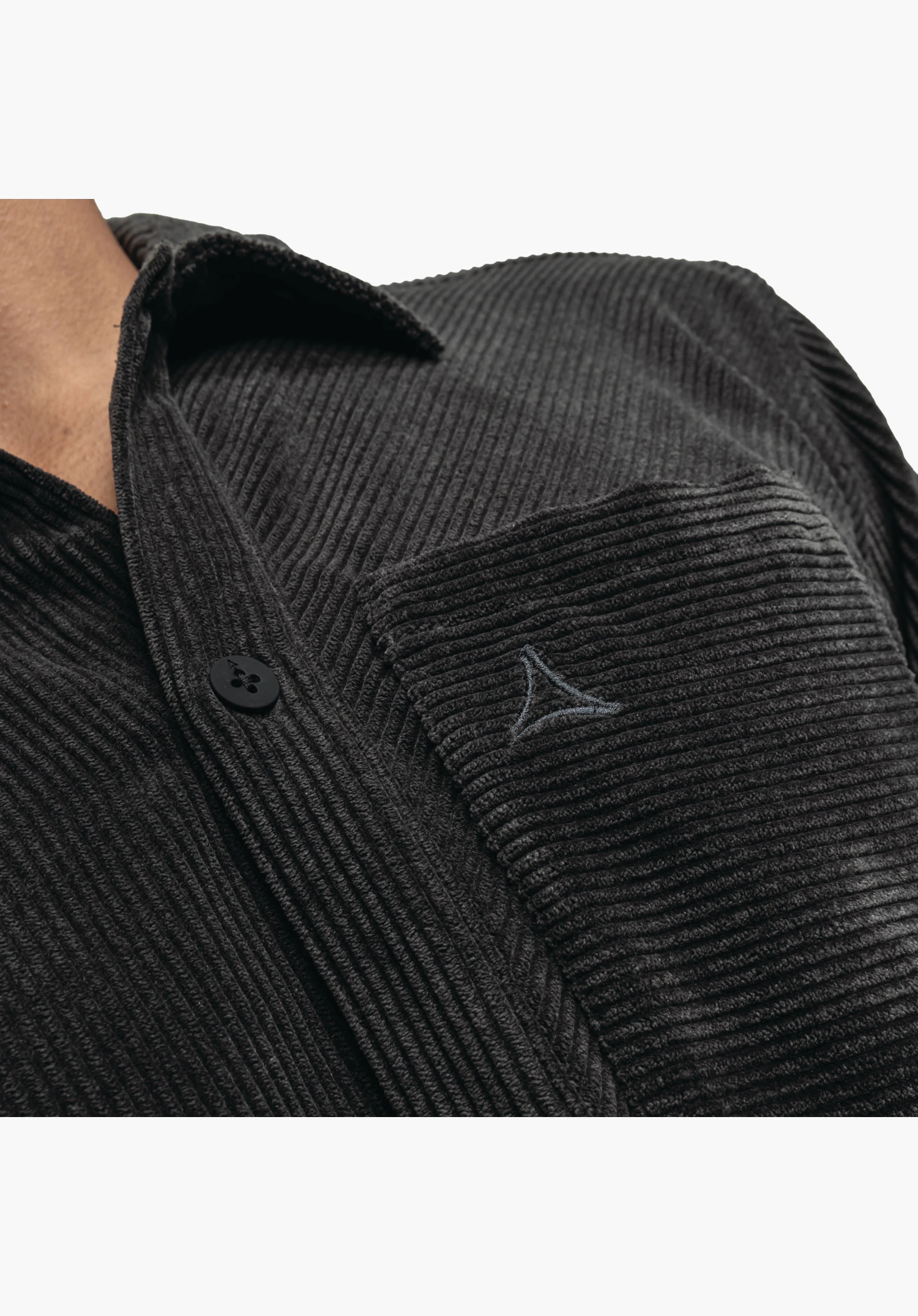 Shirt Style Lodos MNS mit Fokus auf die schwarze Cord-Struktur, die Brusttasche mit gesticktem Schöffel-Logo sowie die Knopfleiste. Nahaufnahme vor weißem/neutralem Hintergrund.
