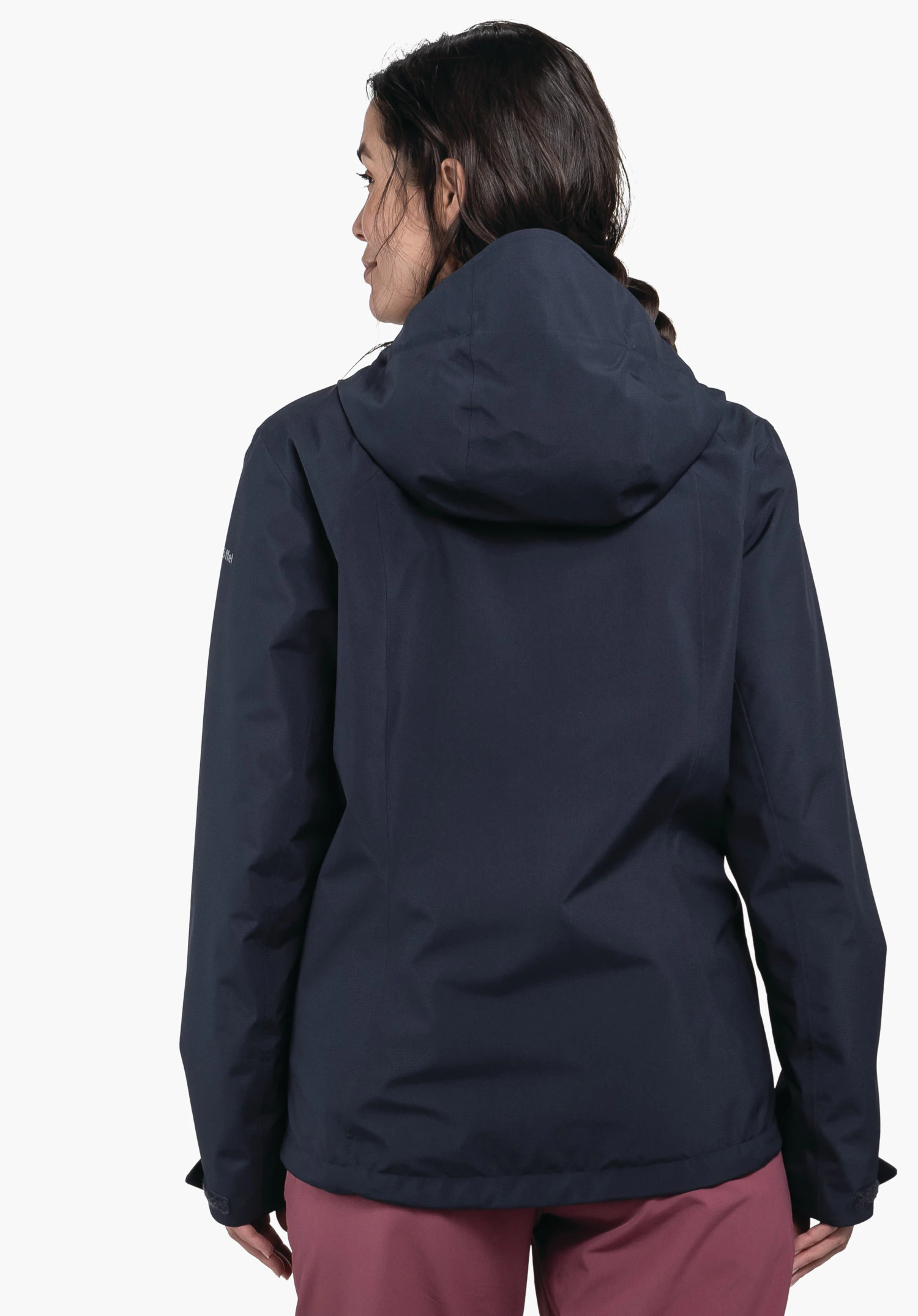 Jacket Style Yew WMS dunkelblaue, taillierte Outdoor-Jacke; Modell trägt sie mit dem Rücken zur Kamera und dreht den Kopf nach links, kombiniert mit lila Hosen, neutraler weißer Studiohintergrund.