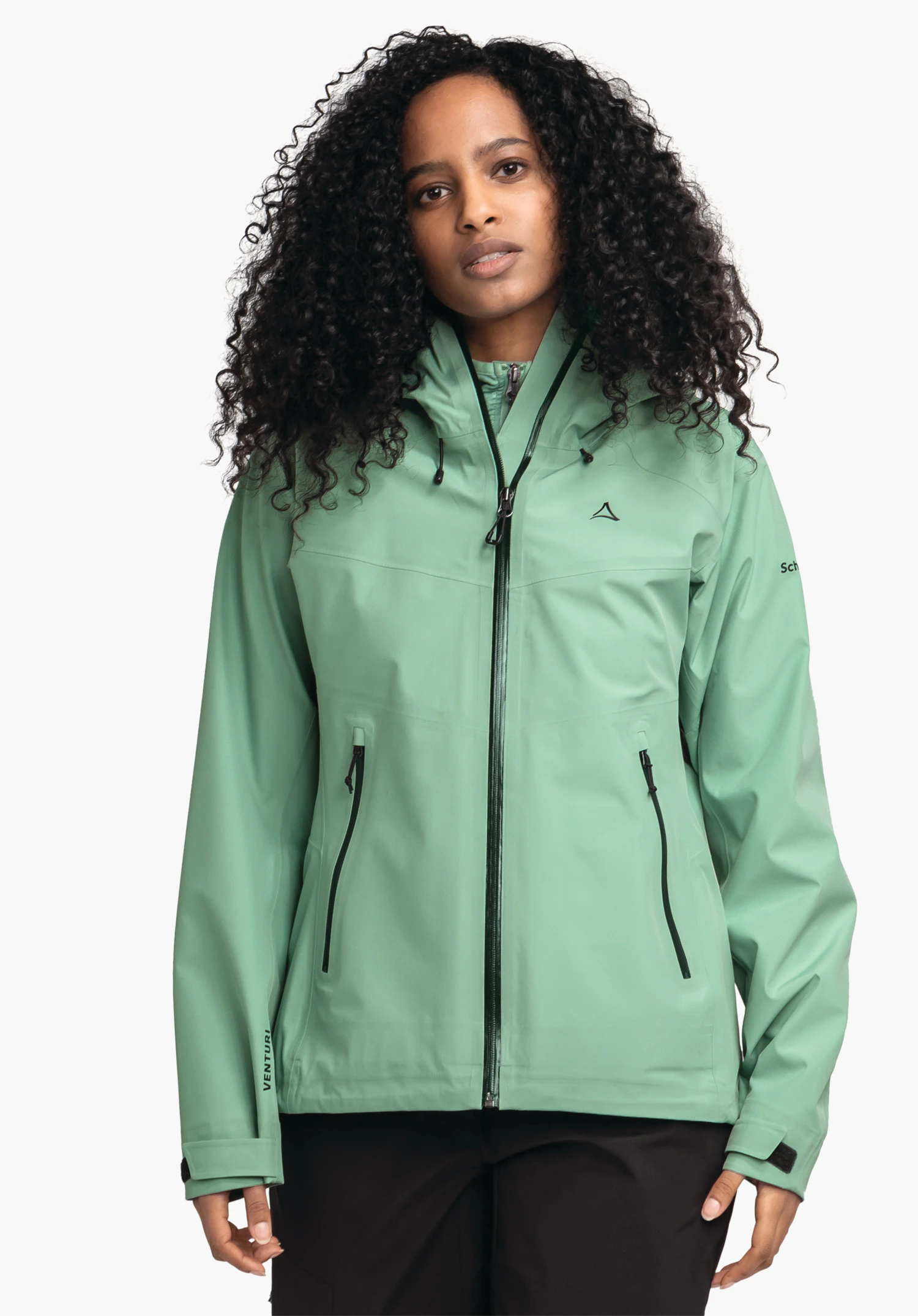 Jacket Style Cascata WMS light green rain jacket with Schöffel logo, worn by a woman with black curly hair against a white background; text: VENTURI; Schöffel.