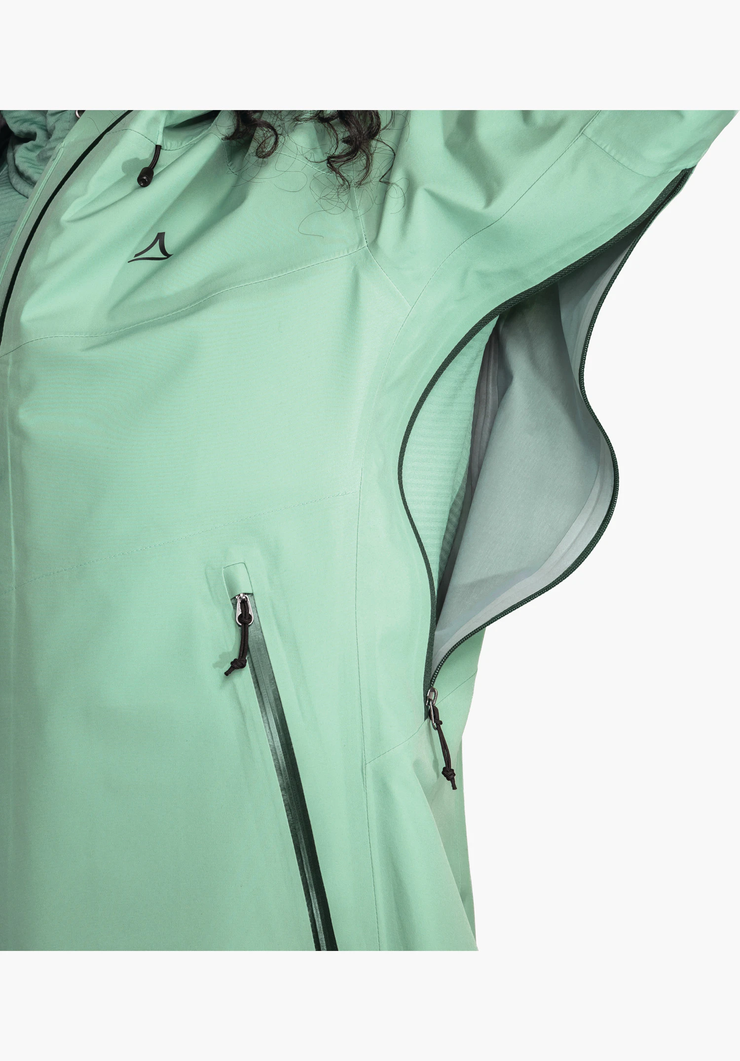 Jacket Style Cascata WMS featuring the soft teddy lining, the black internal pocket with functional icons and the Schöffel logo on the green outer fabric, close-up against a white background.
