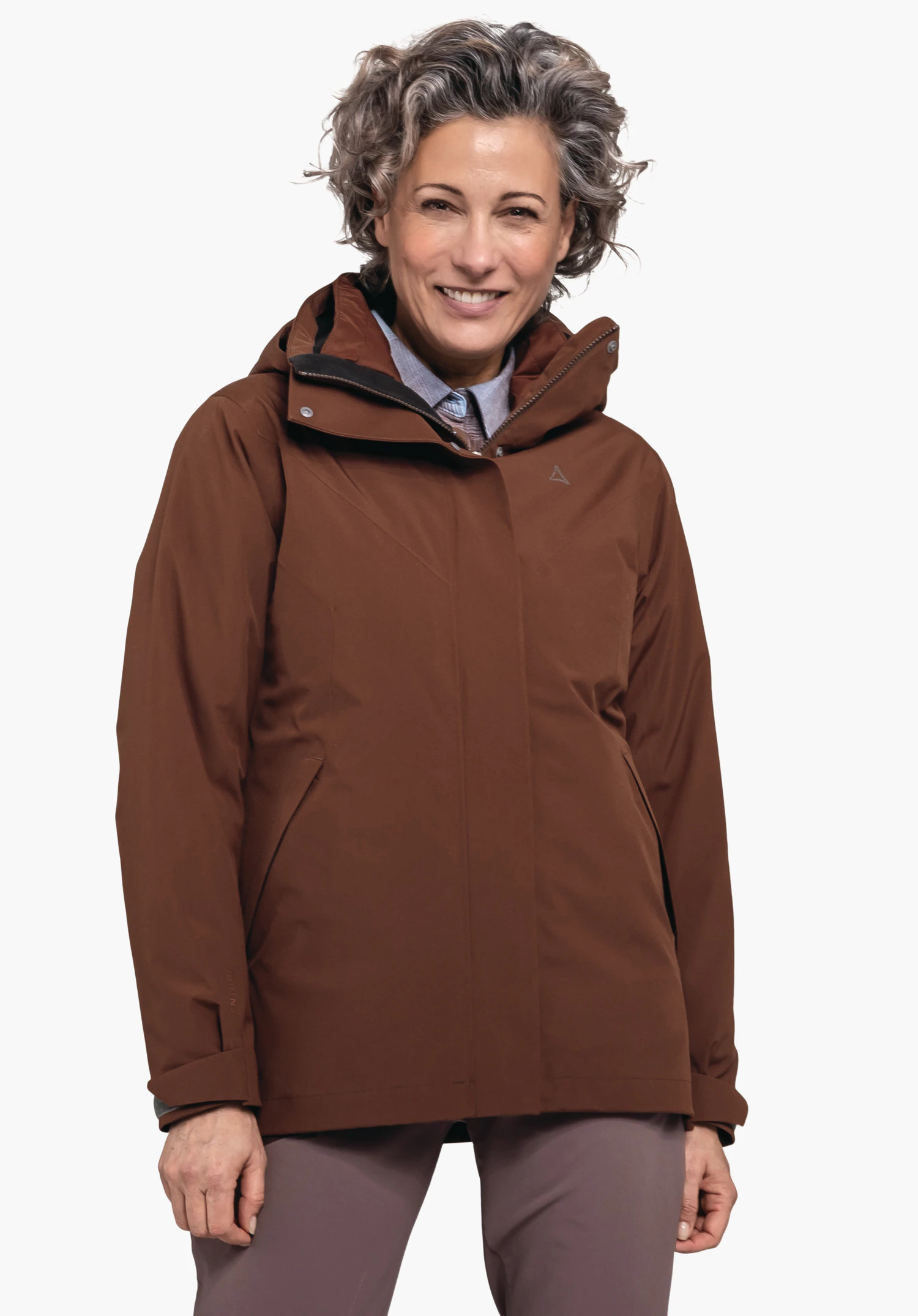 3in1 Jacket Style Tamina WMS smiling woman wearing a dark brown hooded jacket with Schöffel logo on the chest; light grey hair, light blue shirt collar, white background.