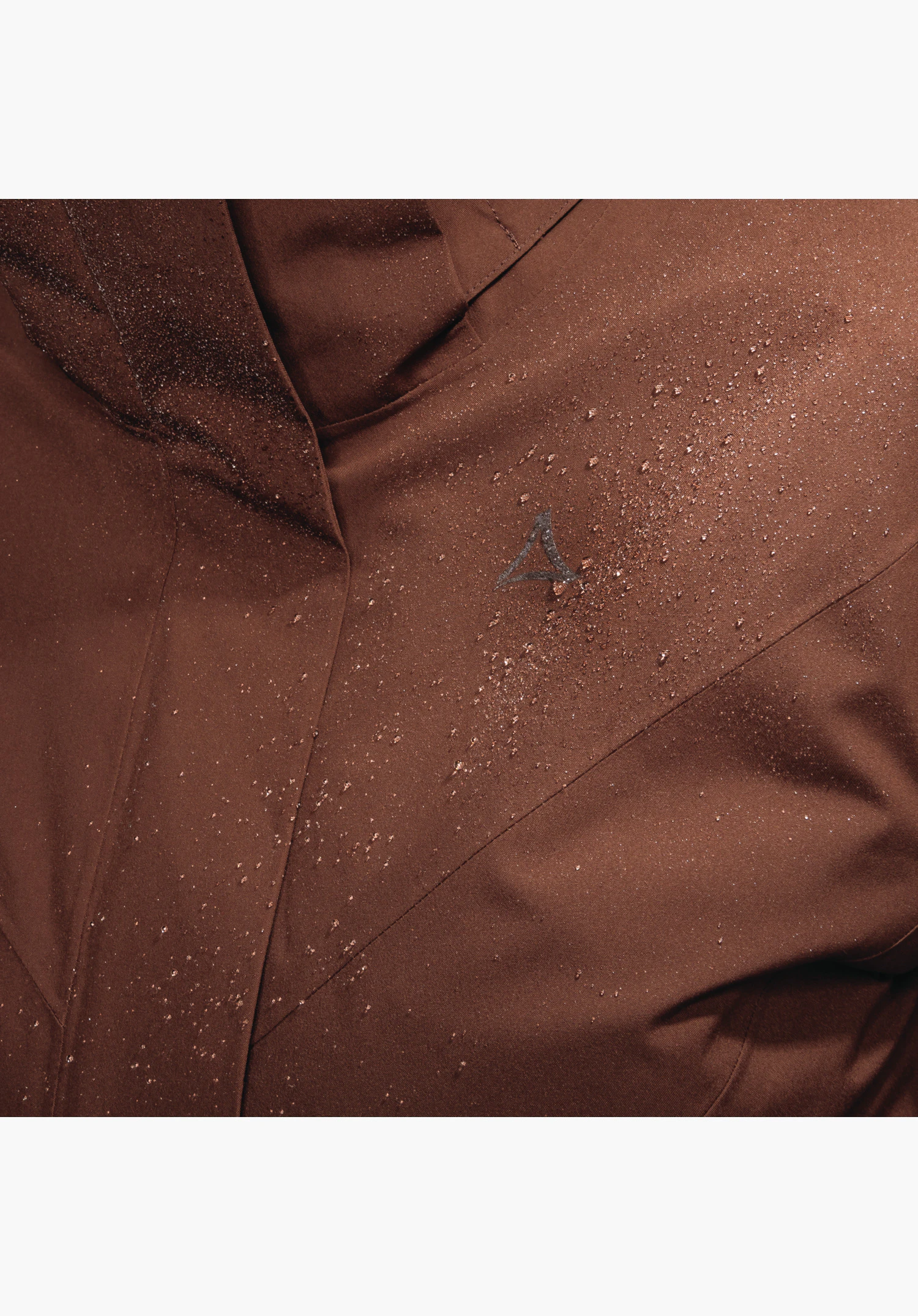 3in1 Jacket Style Tamina WMS zeigt den braunen Stoff mit abperlenden Wassertropfen und dem Schöffel-Logo. Nahaufnahme vor weißem/neutralem Hintergrund.