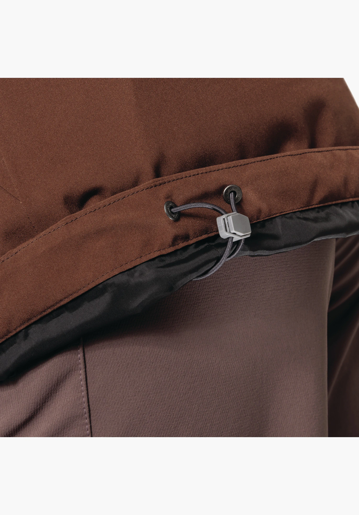 3in1 Jacket Style Tamina WMS zeigt den verstellbaren Tunnelzug mit grauem Stopper und elastischer Kordel am braunen Oberstoff. Nahaufnahme vor weißem/neutralem Hintergrund.