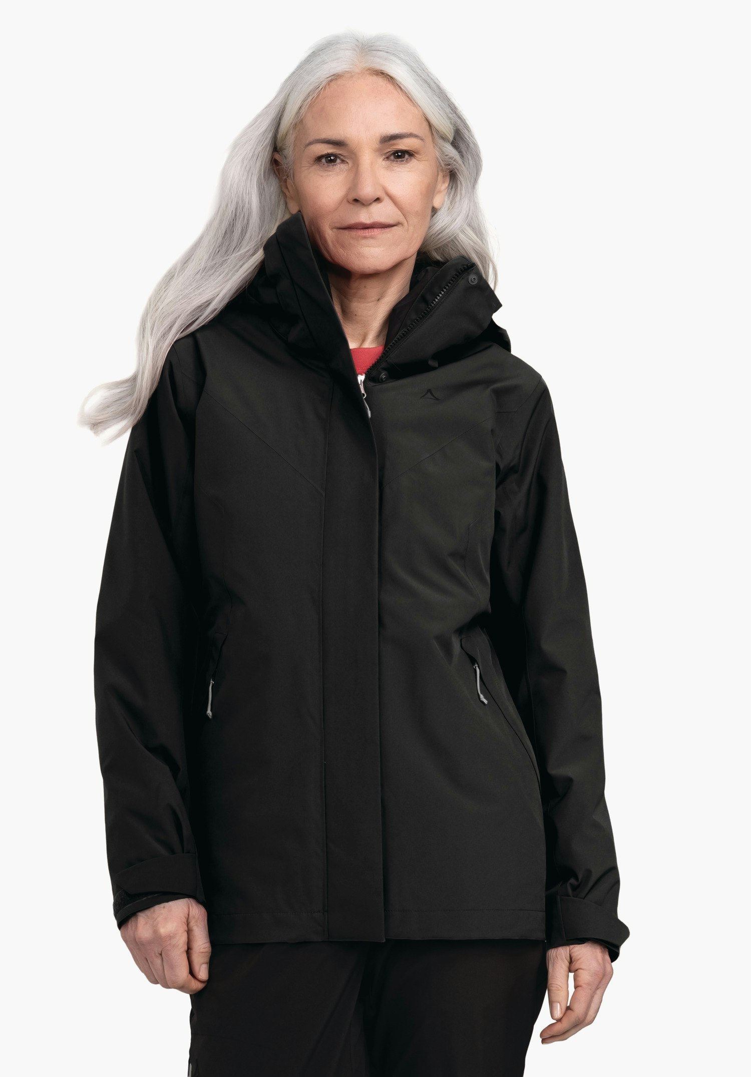 3in1 Jacket Style Tamina WMS Veste noire avec logo Schöffel, portée par une femme aux cheveux gris clair; zippée, capuche relevée, fond clair neutre.