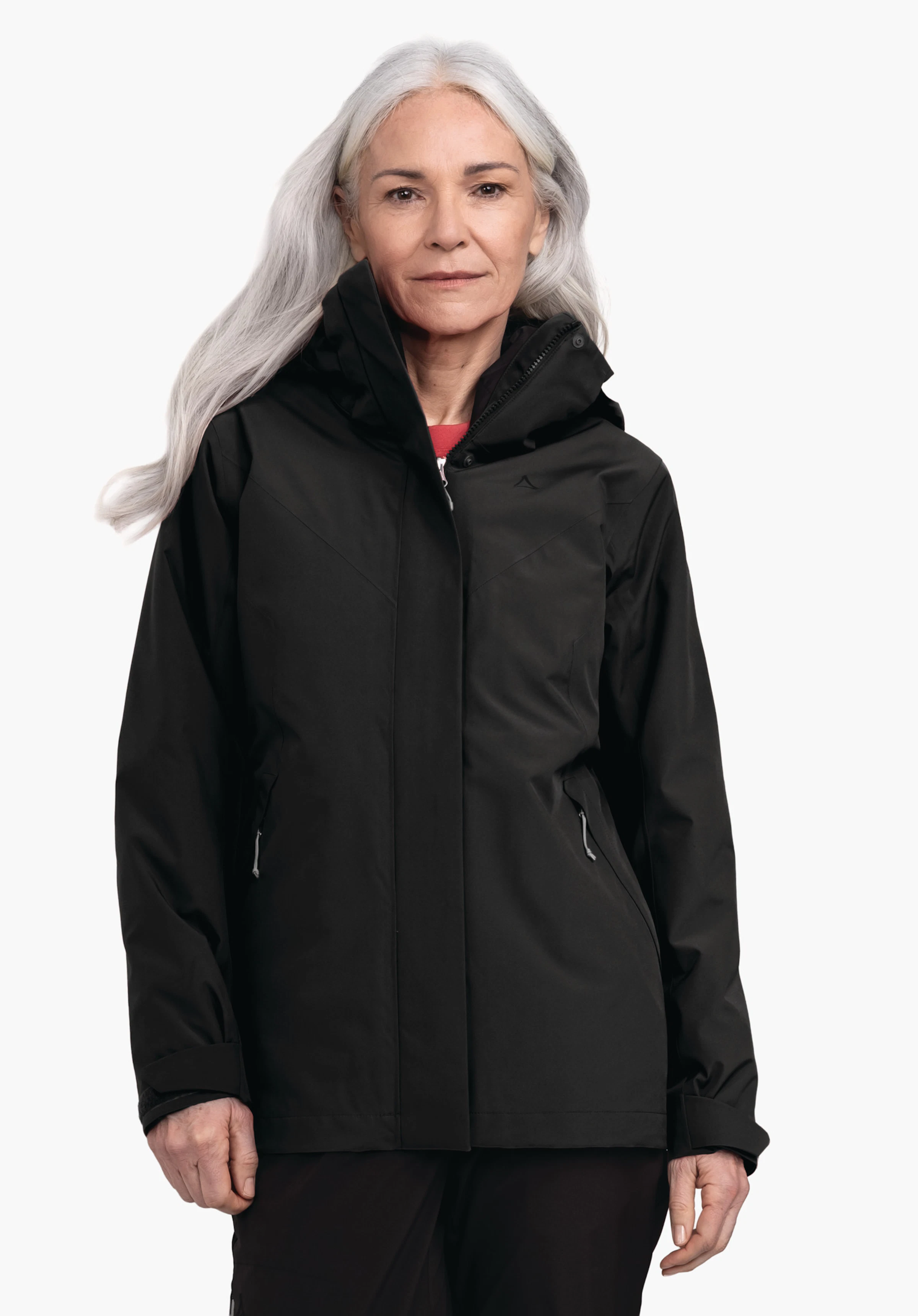 3in1 Jacket Style Tamina WMS Veste noire avec logo Schöffel, portée par une femme aux cheveux gris clair; zippée, capuche relevée, fond clair neutre.