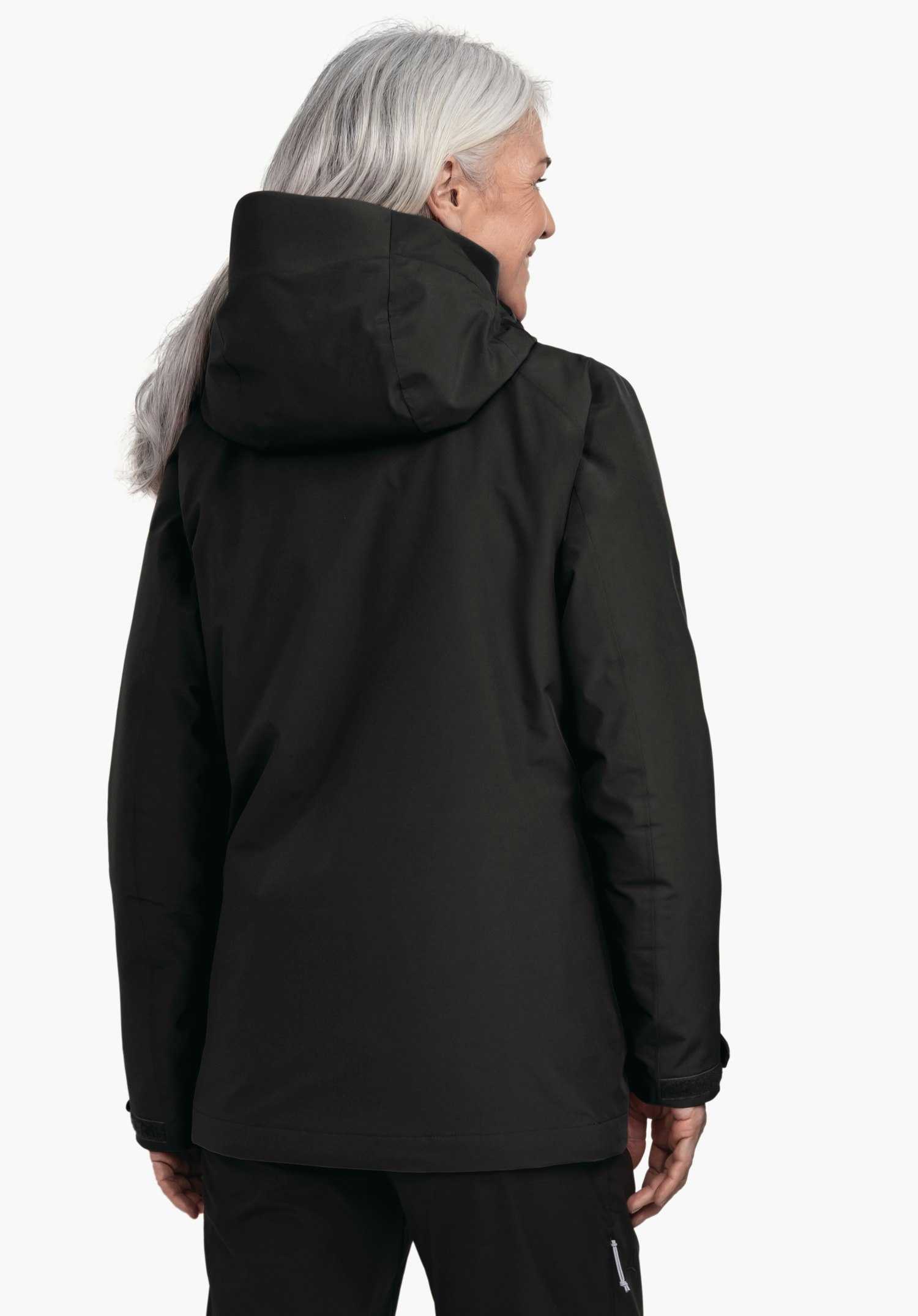 3in1 Jacket Style Tamina WMS veste noire à capuche, portée de dos; femme aux cheveux gris clair regardant vers la droite en souriant; fond blanc neutre.