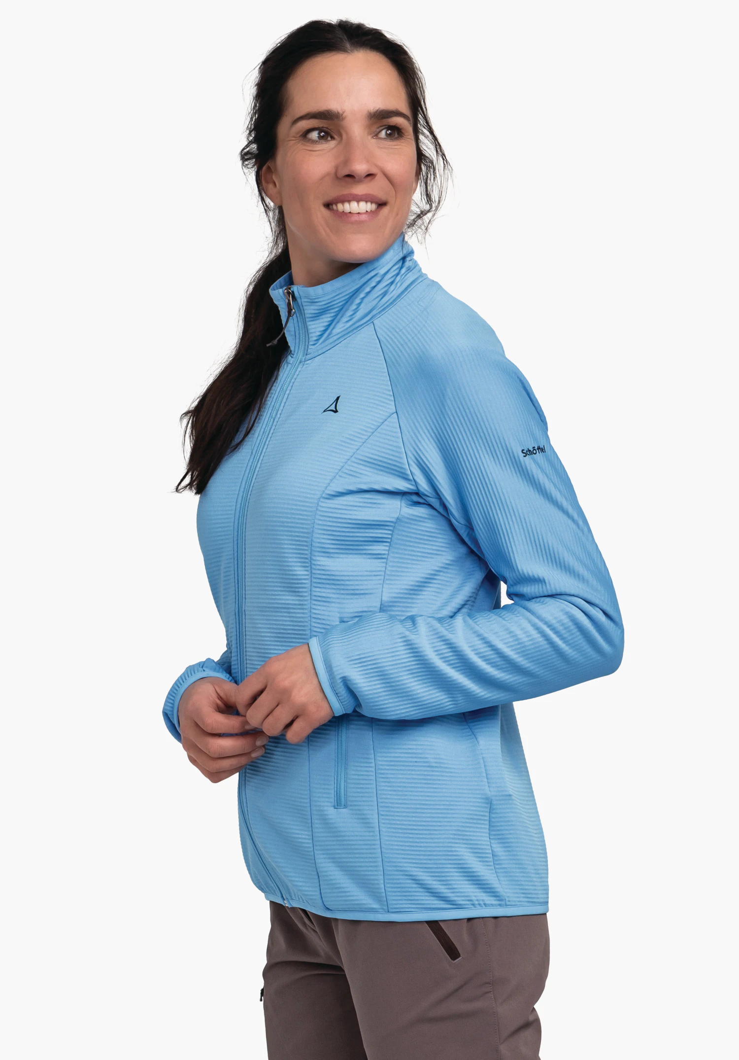 Fleece Jk Style Cascata WMS light blue jacket with Schöffel logo, worn by a woman smiling and looking side-on; white studio background. Text: "Schöffel".