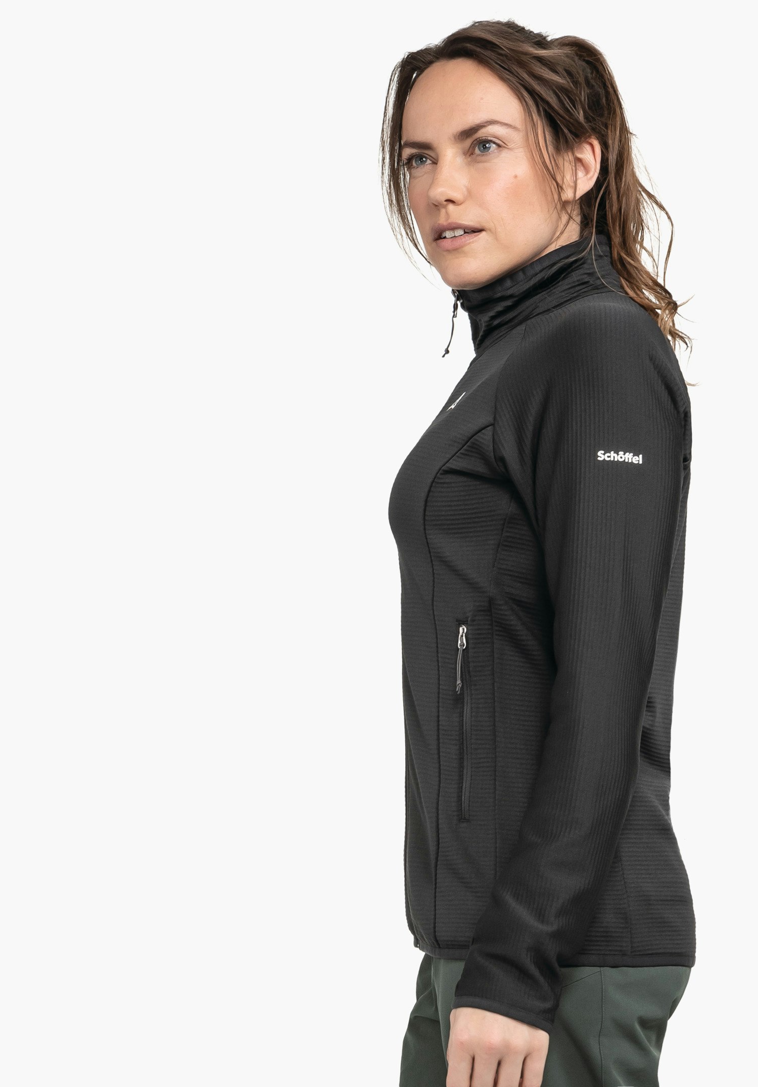 Fleece Jk Style Cascata WMS black fleece jacket worn from a side view; model stands and looks slightly forward in a light neutral environment. Text on sleeve: "Schöffel". Schöffel logo on chest.