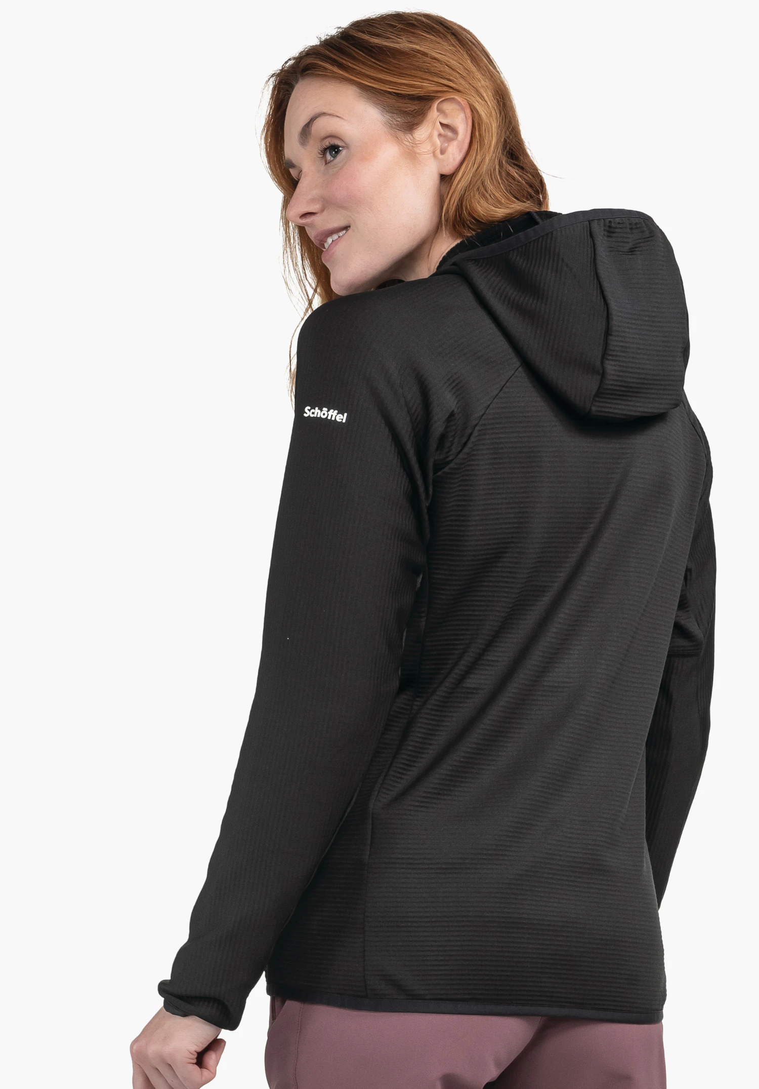 Fleece Hoody Style Cascata WMS veste à capuche noire, portée par une femme, vue arrière et manches visibles; inscription blanche « Schöffel » sur la manche; fond studio blanc.