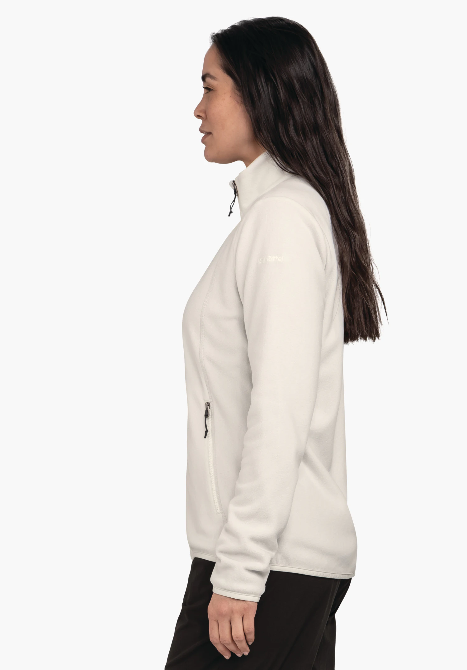 Fleece Jk Style Ash WMS lichtwitte fleecejas, gedragen door een vrouw in profiel; zij staat rustig met ontspannen armen, rits gesloten, voor een lichte effen achtergrond. Tekst op de mouw: "Schöffel".