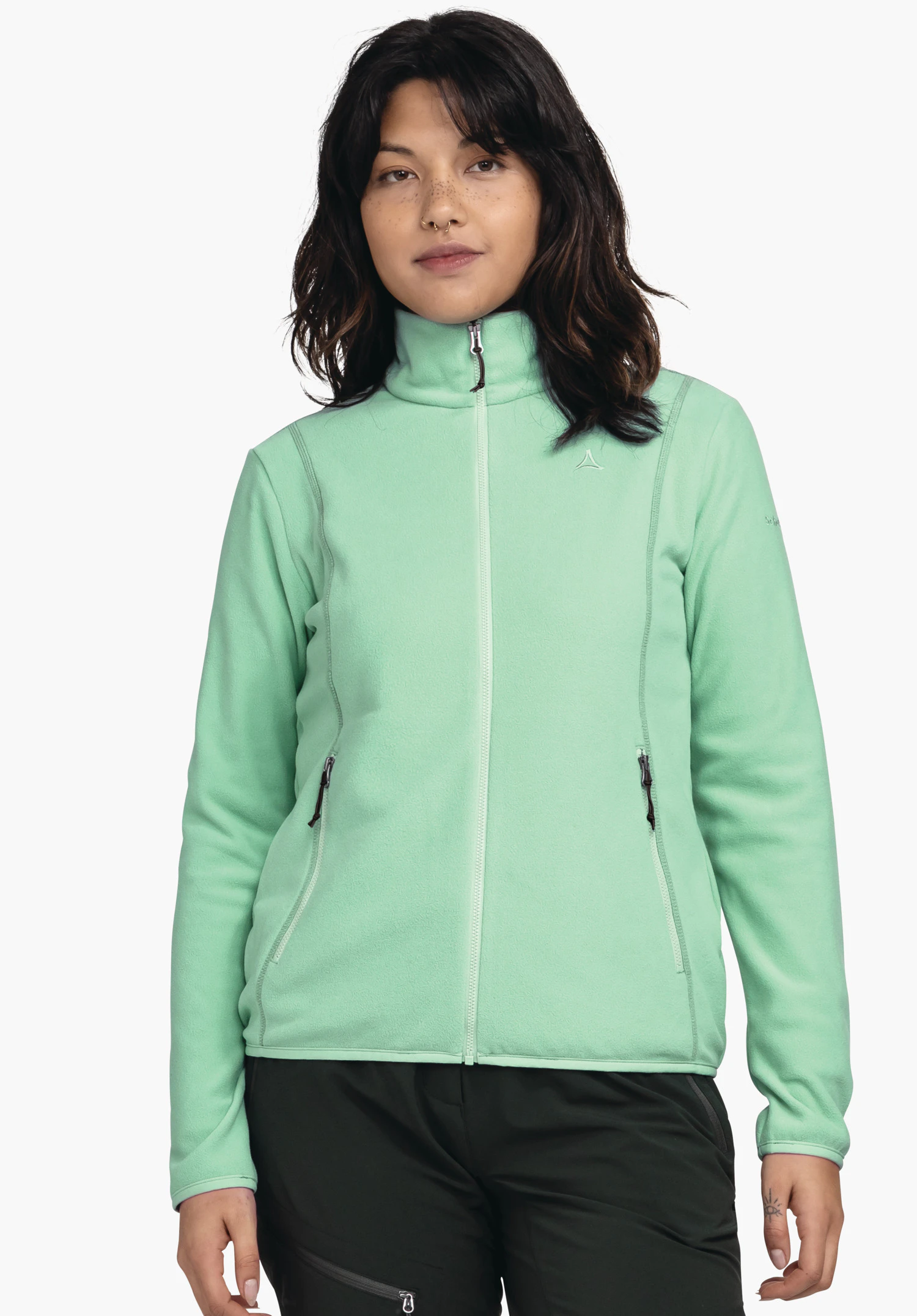 Fleece Jk Style Ash WMS light green fleece jacket worn front-facing; zip closed, two side zip pockets, high collar; small Schöffel logo on the left chest; person standing against a white background.