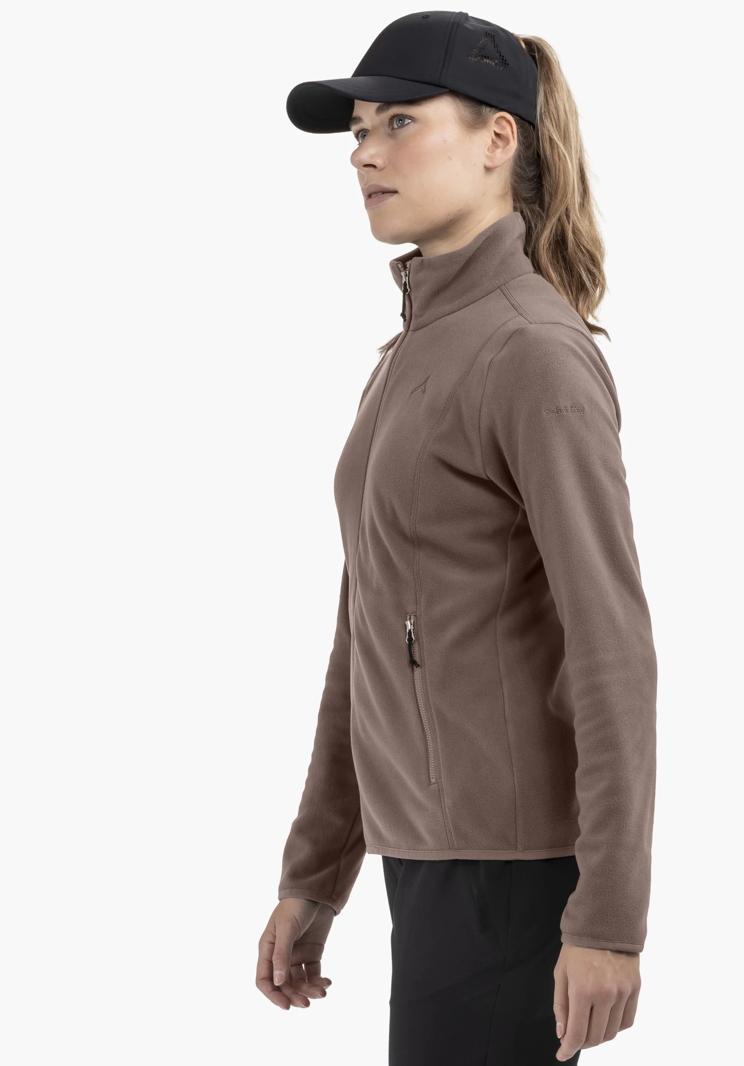 Fleece Jk Style Ash WMS in brown, worn by a model standing sideways against a neutral background. The fleece jacket features a subtle Schöffel-Logo on the sleeve, perfect for alpine adventures.