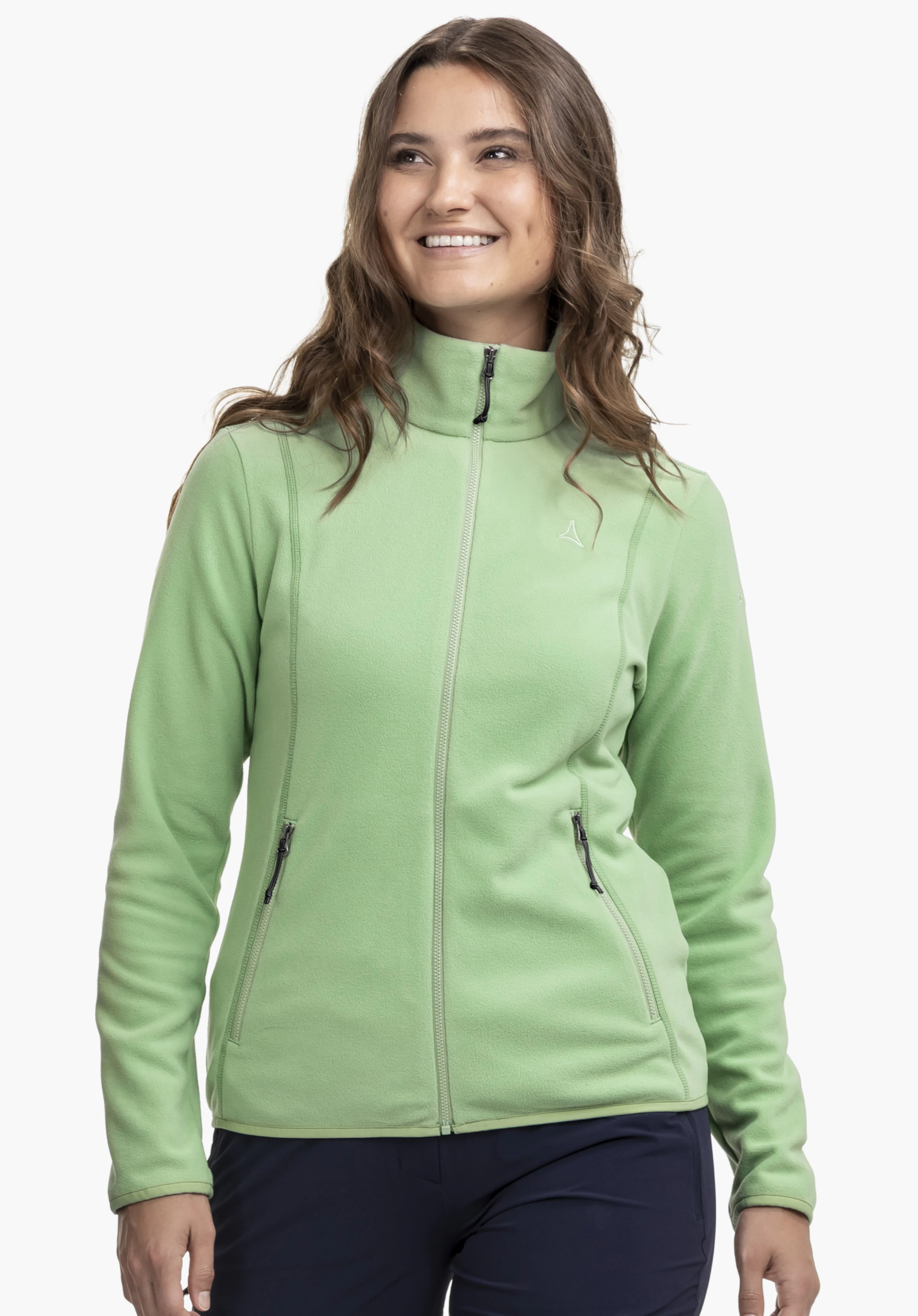 Fleece Jk Style Ash WMS. Een model staat frontaal en draagt het groene fleecejack met een zichtbaar Schöffel-logo op de linkerborst. Gepresenteerd tegen een neutrale achtergrond.