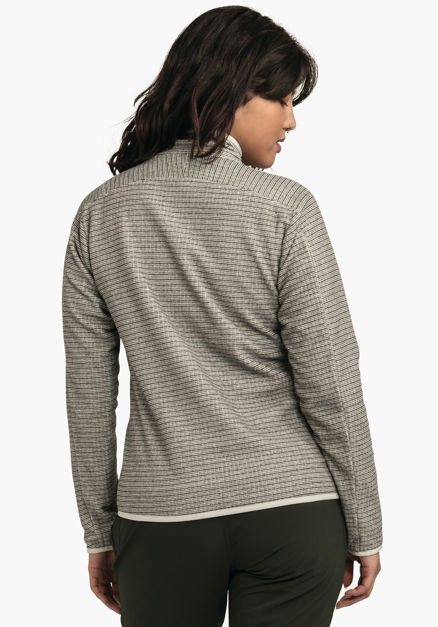 CIRC Fleece Jk Style Terxa WMS veste gris clair à fines rayures, portée par une personne debout dos à la caméra et tournant la tête sur le côté; contexte: fond blanc neutre, pantalon vert foncé visible.