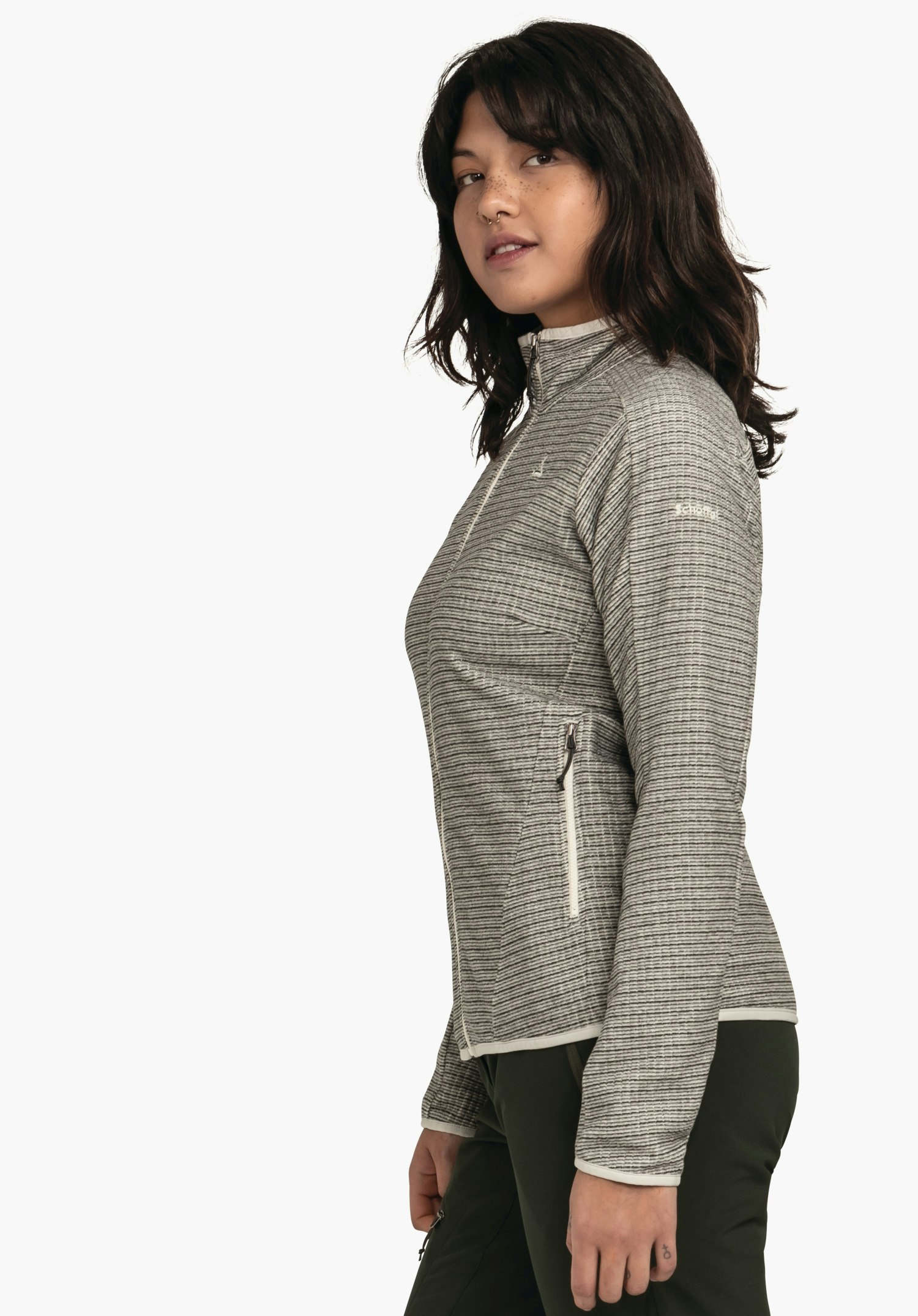 CIRC Fleece Jk Style Terxa WMS veste gris clair finement rayée avec fermeture éclair (logo Schöffel) portée par une femme debout de profil et souriant légèrement; fond blanc. Texte: "Schöffel".