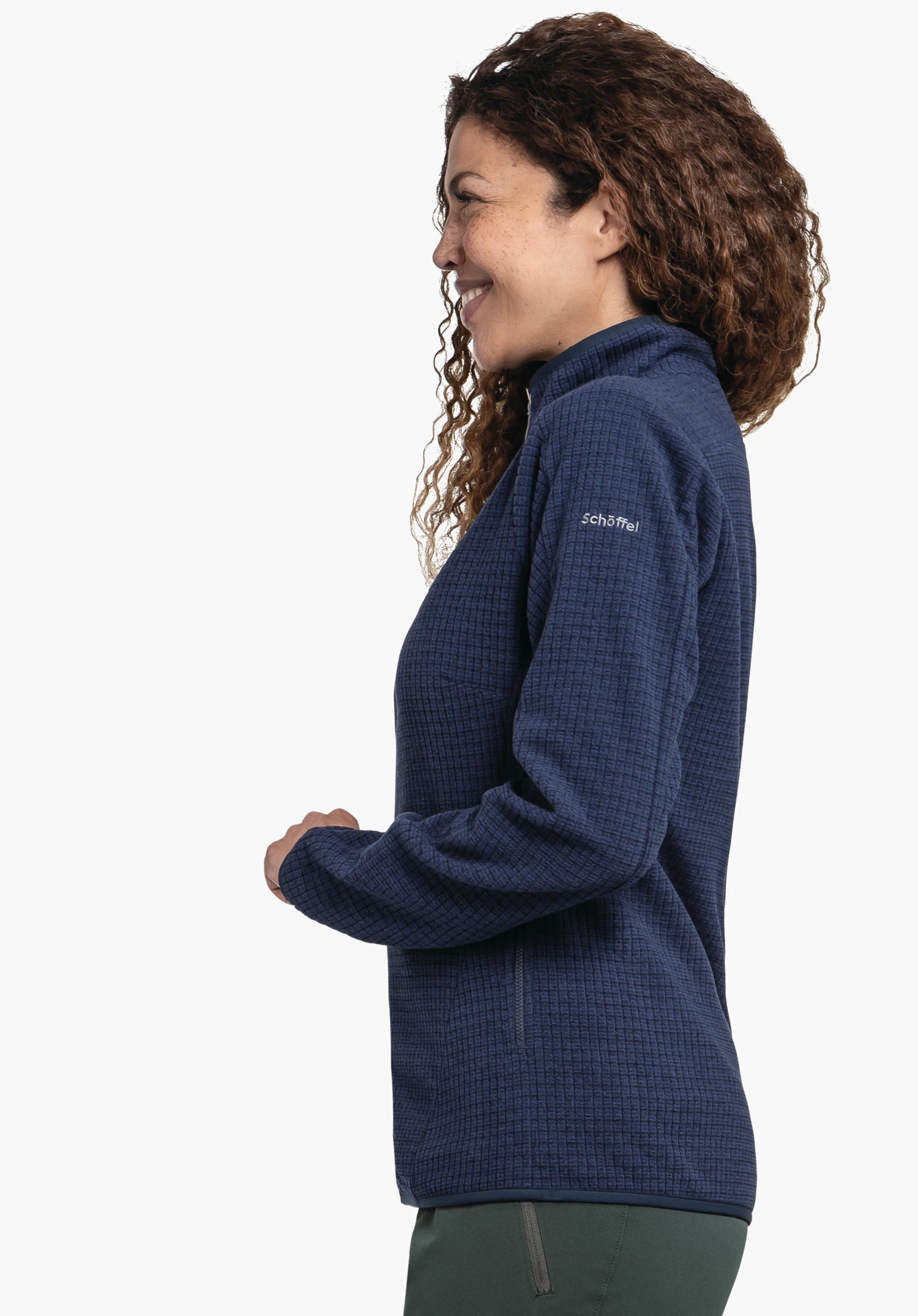 CIRC Fleece Jk Style Terxa WMS dark blue women’s fleece jacket worn side-on by a smiling woman, hands in front of the body, wearing green trousers, in front of a white background; text on sleeve: "Schöffel".