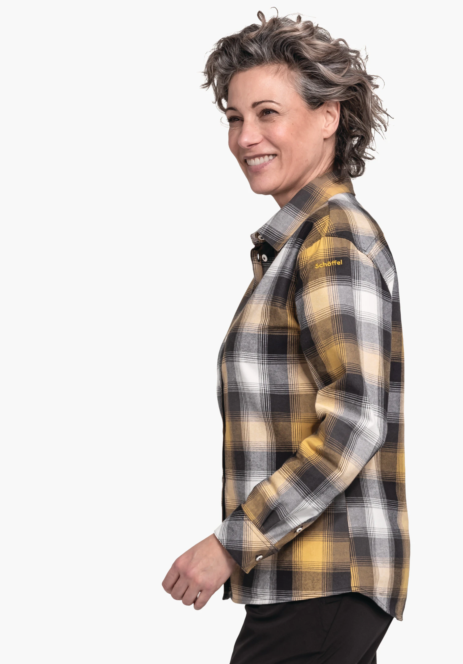 Blouse Style Limedes WMS geruite blouse, gedragen door een glimlachende vrouw in zijaanzicht voor een lichte achtergrond; geruit in geel, wit, lichtgrijs en zwart. Tekst op de schouder: "Schöffel".
