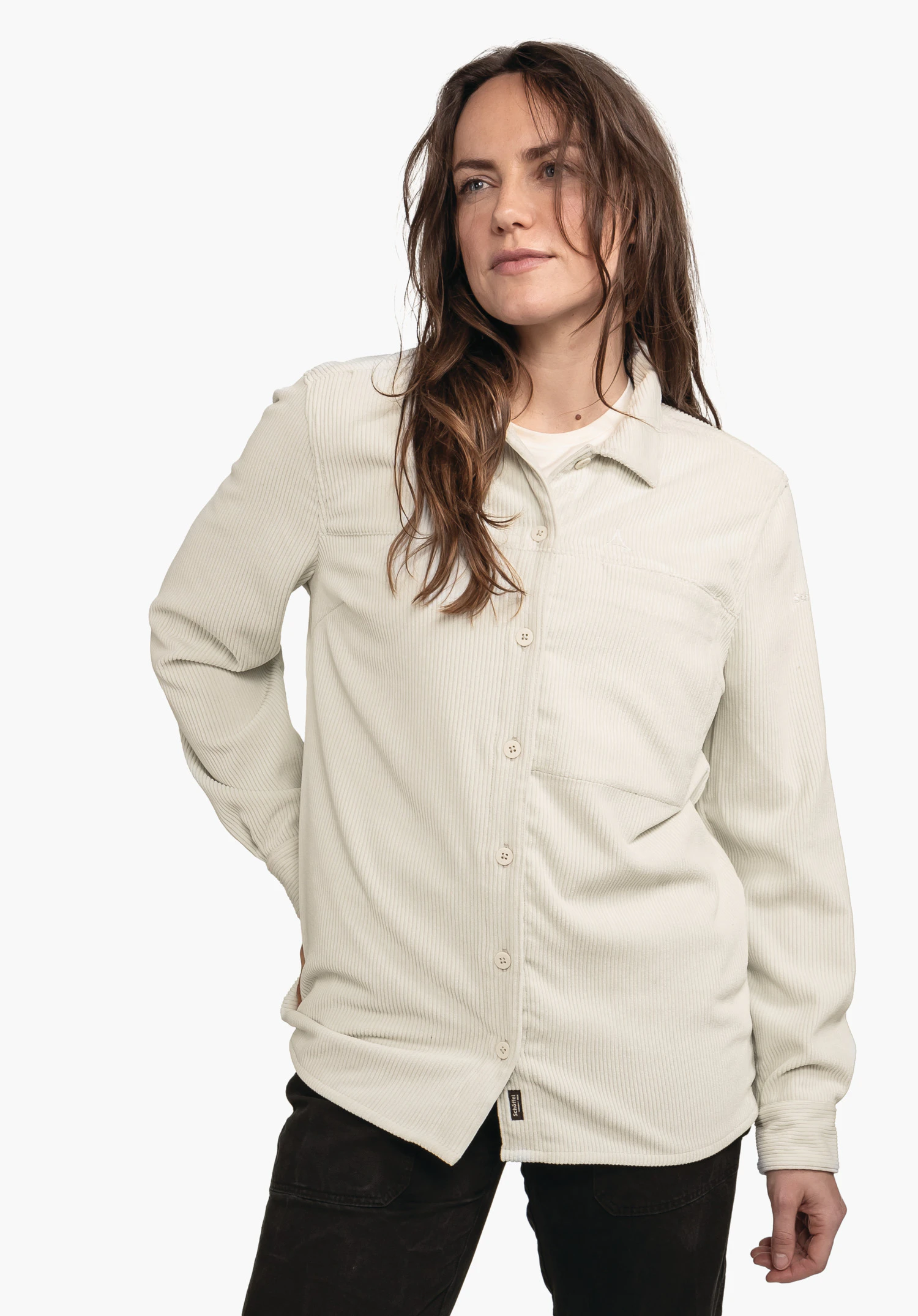 Blouse Style Lodos WMS lichtgroen corduroy overhemd, vooraan geknoopt, los vallend gedragen door een vrouw; Schöffel-logo op de borst, wit ondershirt, zwarte broek, lange krullende zwarte haren, witte achtergrond.