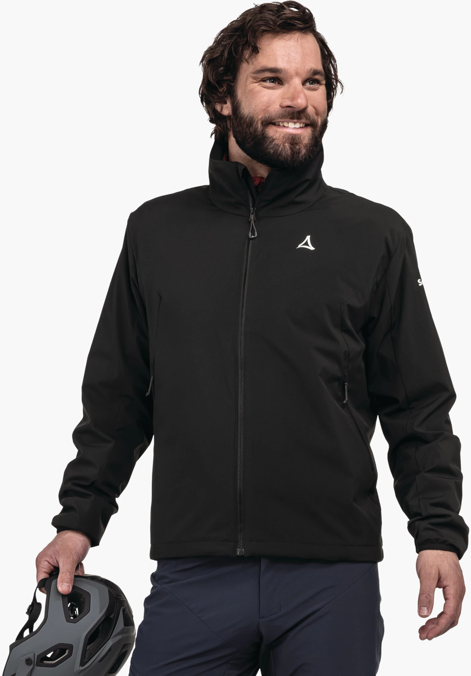 Ins Jacket Style Salza MNS black jacket with Schöffel logo on the chest; man holds a grey bicycle helmet, smiling while standing against a white background; dark blue trousers. Text: Schöffel.