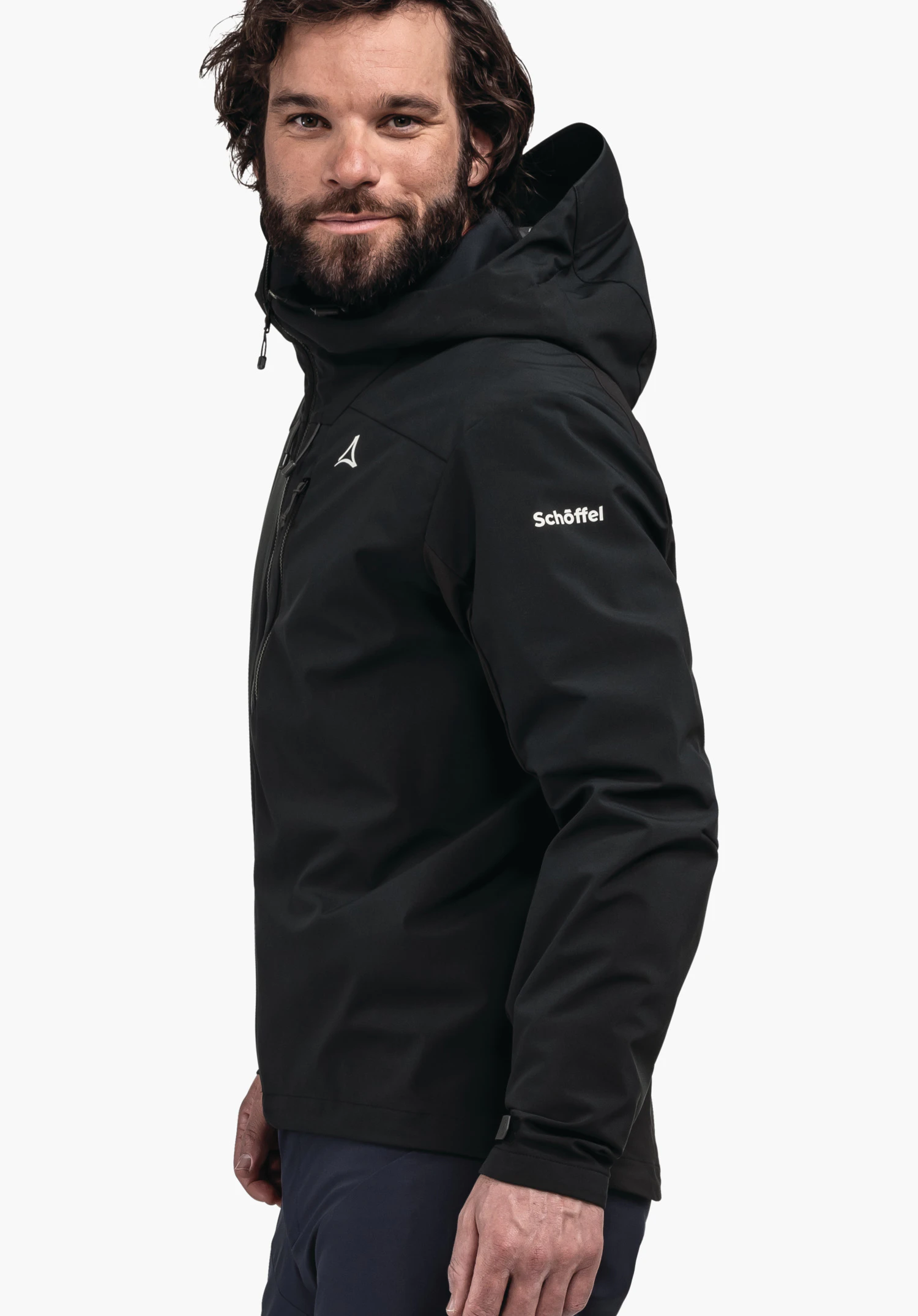 Hybrid Jk Style Salza MNS black hooded outdoor jacket with Schöffel logo, worn by a bearded man slightly turned to the side; context: plain white background. Text on sleeve: "Schöffel".