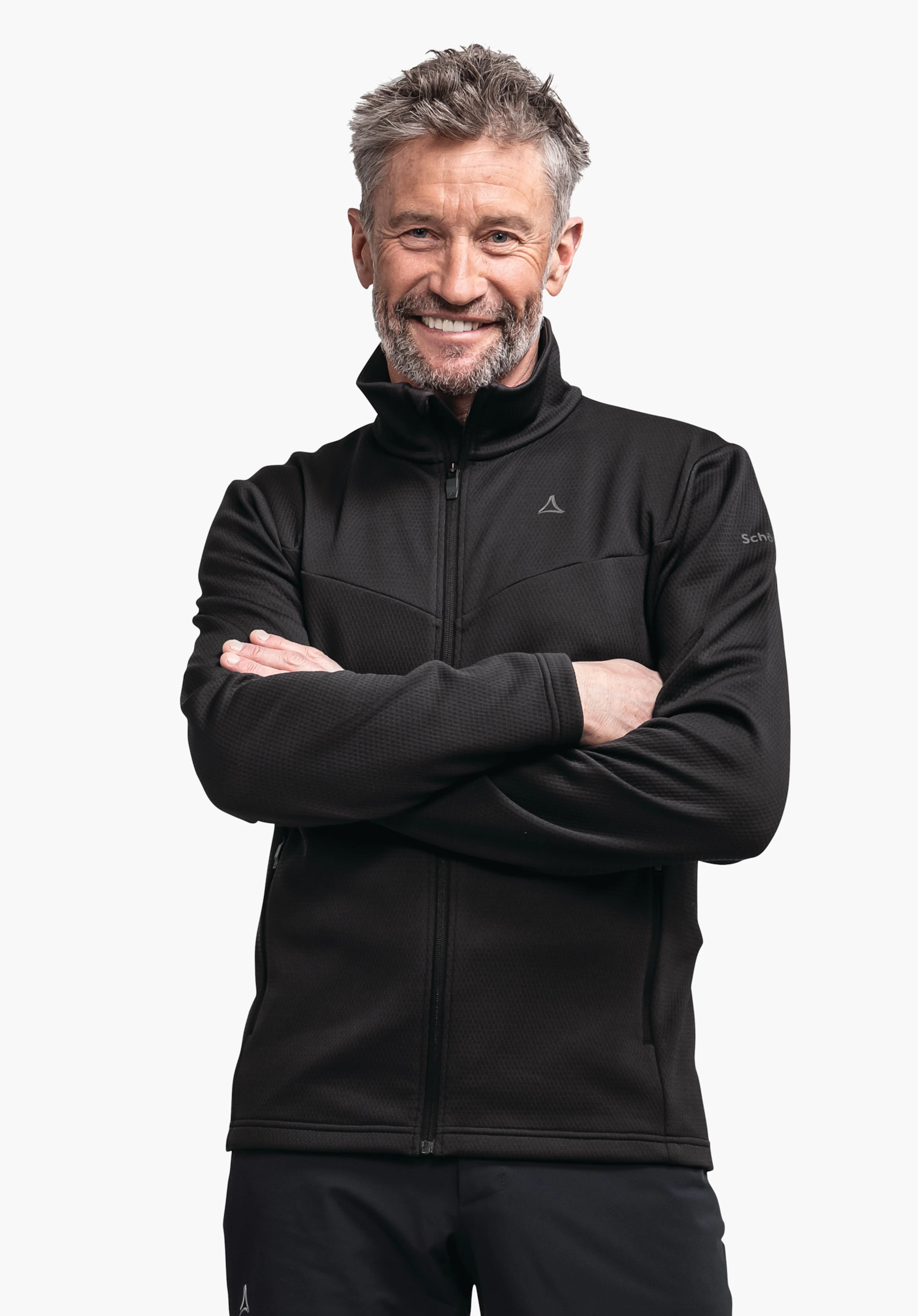 Fleece Jk Style Pine MNS Schwarze Jacke, Mann lächelt und steht mit verschränkten Armen; Schöffel-Logo auf Brust, Schrift "Schöffel" auf Ärmel; freigestellter weißer Hintergrund.