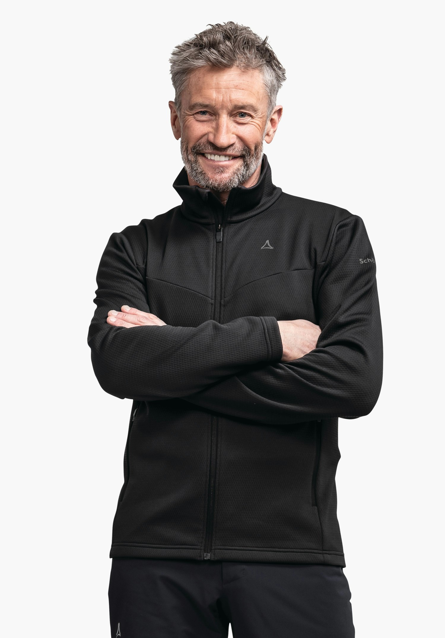 Fleece Jk Style Pine MNS Schwarze Jacke, Mann lächelt und steht mit verschränkten Armen; Schöffel-Logo auf Brust, Schrift "Schöffel" auf Ärmel; freigestellter weißer Hintergrund.