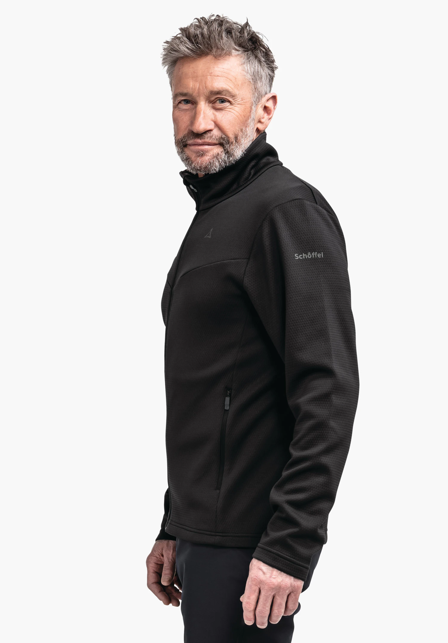 Fleece Jk Style Pine MNS black fleece jacket worn by a standing man; side view, Schöffel logo on chest, lettering "Schöffel" on sleeve; neutral white background.
