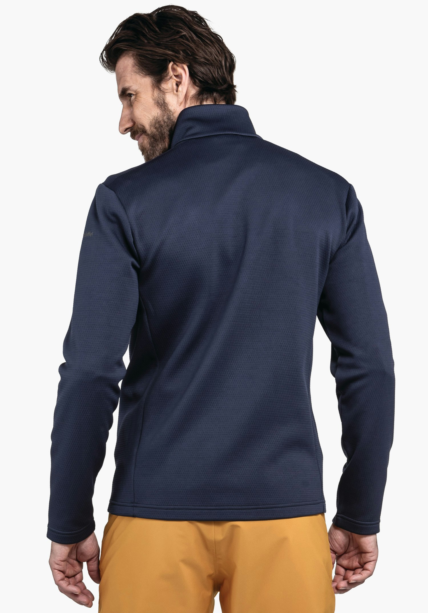 Fleece Jk Style Pine MNS Dunkelblaue Jacke, getragen von einem Mann, steht halb gedreht mit Blick nach links; Kontext: neutraler weißer Hintergrund, trägt orange Hose.
