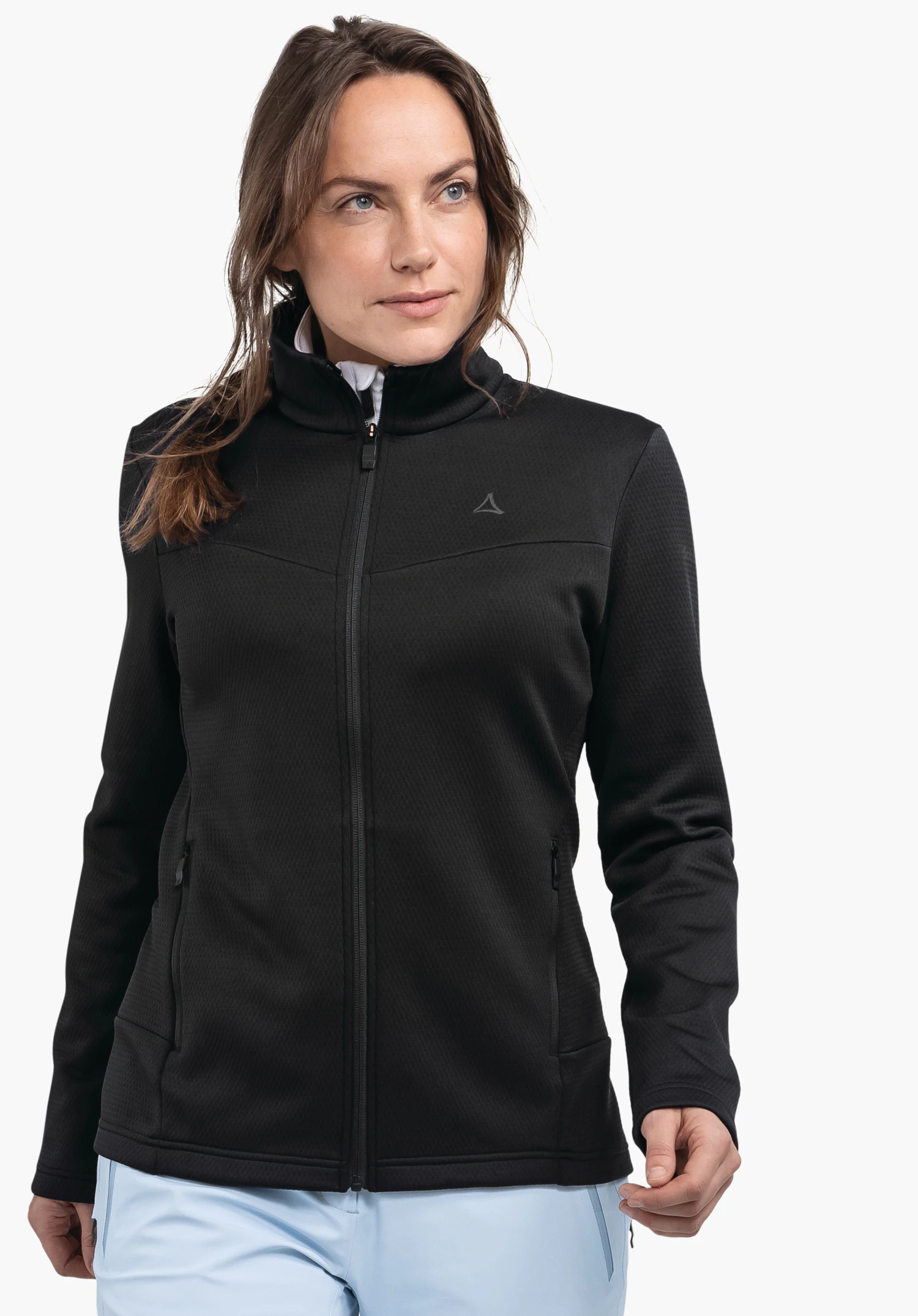 Fleece Jk Style Pine WMS black long-sleeve jacket with Schöffel logo on the chest, worn by a woman looking to the right; light blue trouser leg visible; white background.