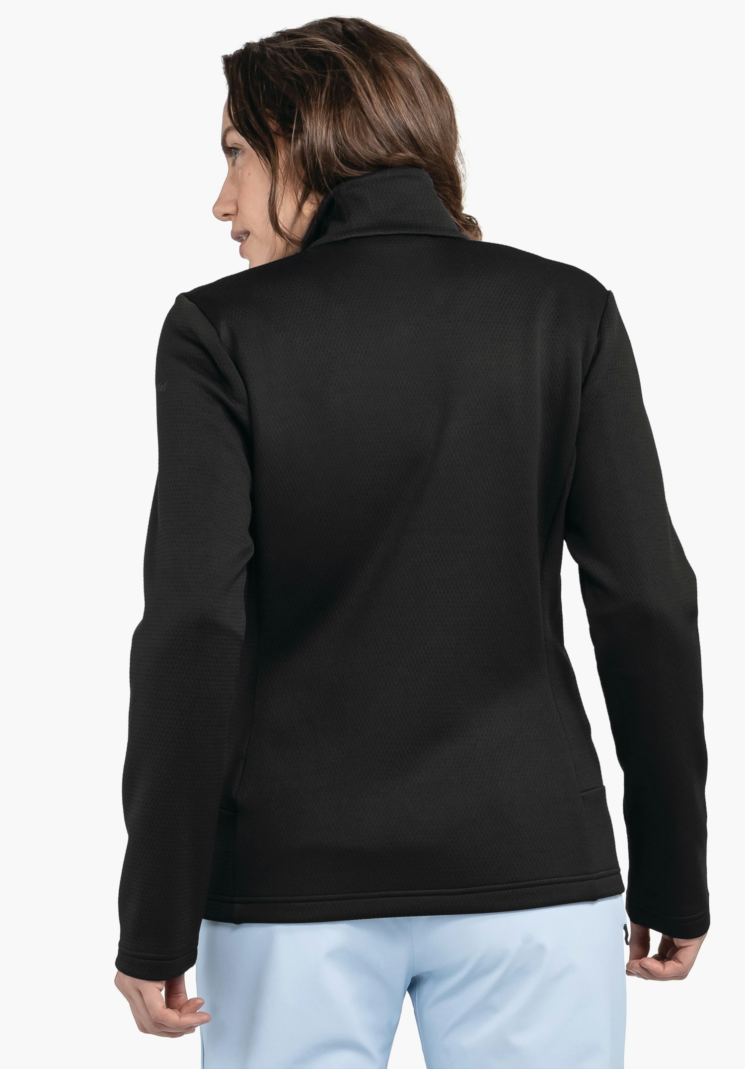 Fleece Jk Style Pine WMS veste noire, portée par une personne debout dos à la caméra; pantalon bleu clair; fond blanc neutre.