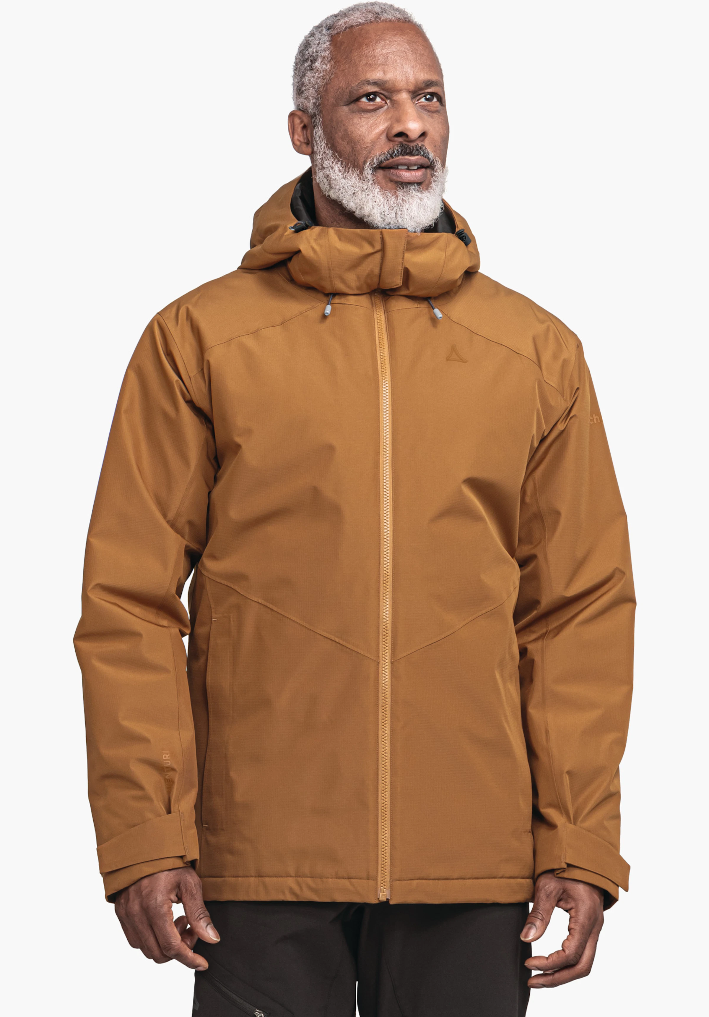 Ins Jacket Style Wildkar MNS Dunkel orange Jacke, getragen von einem Mann, steht frontal und blickt nach oben rechts; Schöffel-Logo auf der Brust, Kapuze angelegt, schwarze Hosen, weißer Studiohintergrund.