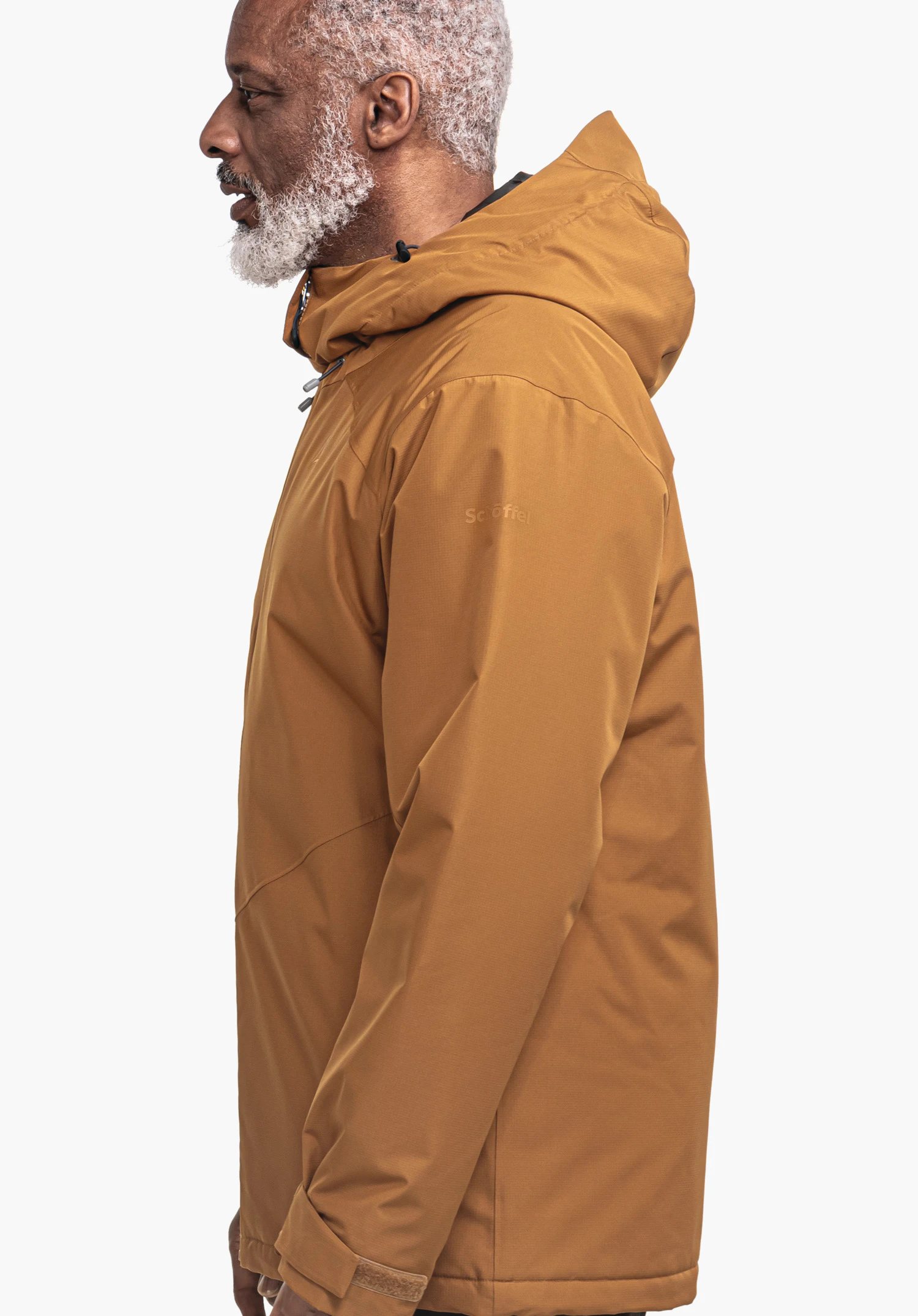 Ins Jacket Style Wildkar MNS Dunkelorange Kapuzenjacke; ein älterer Mann steht im Profil und trägt sie; neutraler weißer Hintergrund. Text auf Ärmel: "Schöffel".