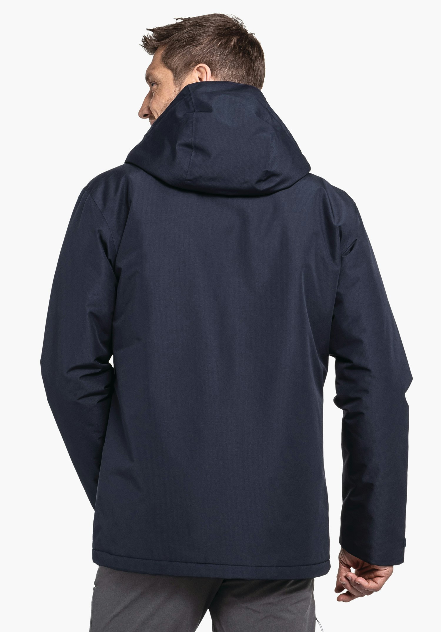 Ins Jacket Style Wildkar MNS dunkelblaue Jacke; Mann trägt sie, steht mit dem Rücken zur Kamera, Kapuze aufgesetzt, vor neutralem Hintergrund.