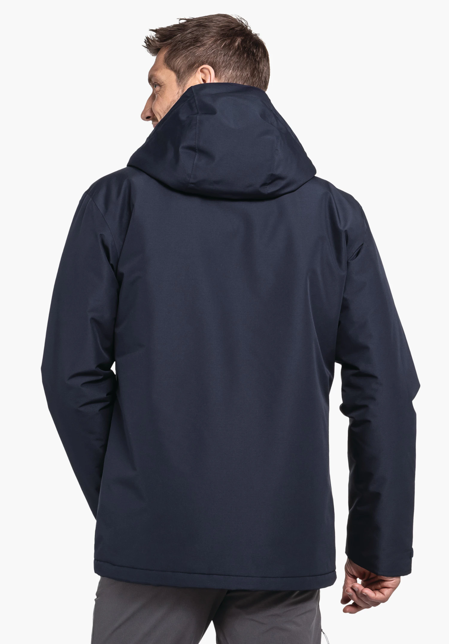 Ins Jacket Style Wildkar MNS dunkelblaue Jacke; Mann trägt sie, steht mit dem Rücken zur Kamera, Kapuze aufgesetzt, vor neutralem Hintergrund.