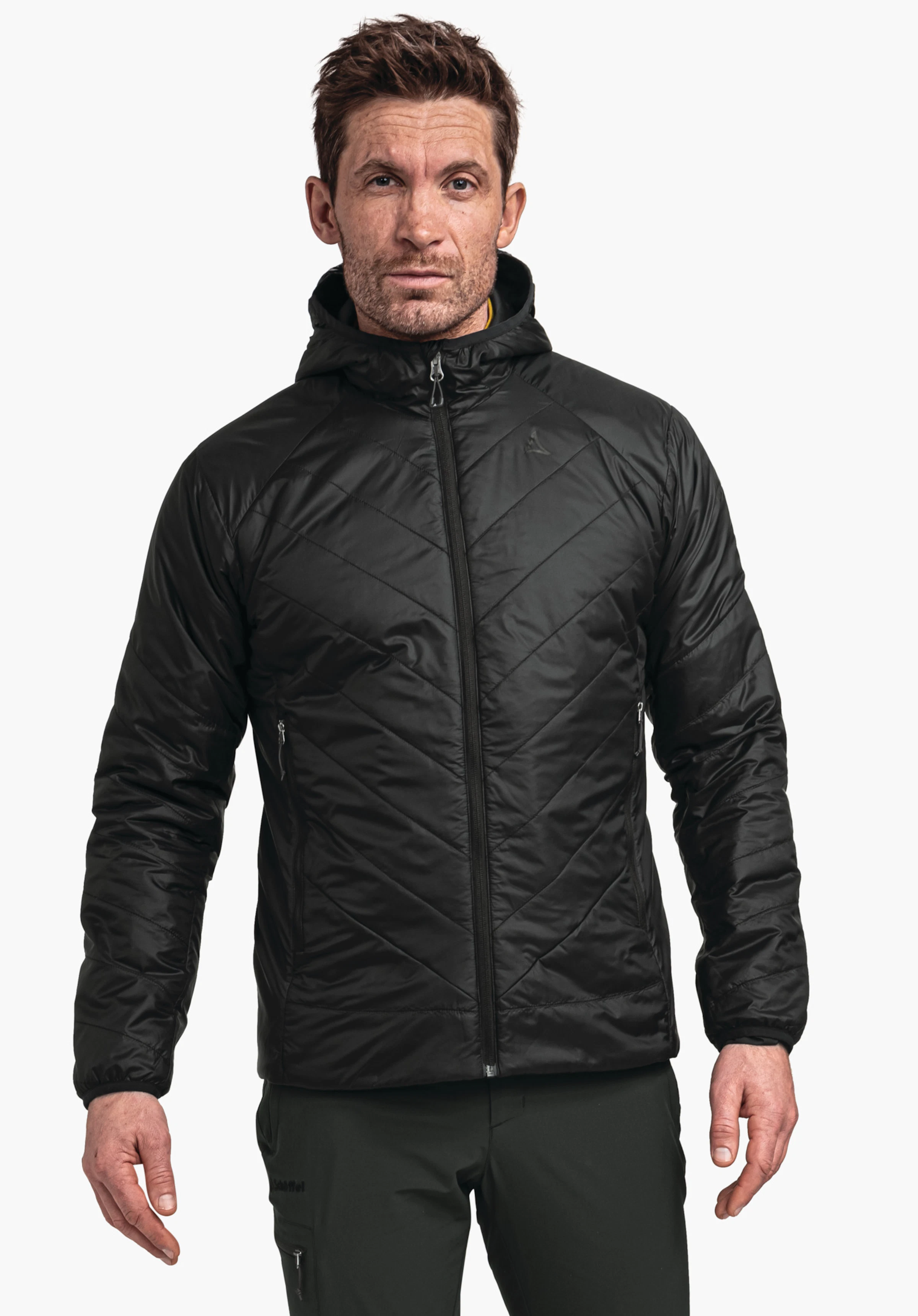 Ins Jacket Style Cascata MNS black quilted jacket, worn by a man standing front-facing against a light grey background; Schöffel logo on the chest, “Schöffel” lettering on the trousers.