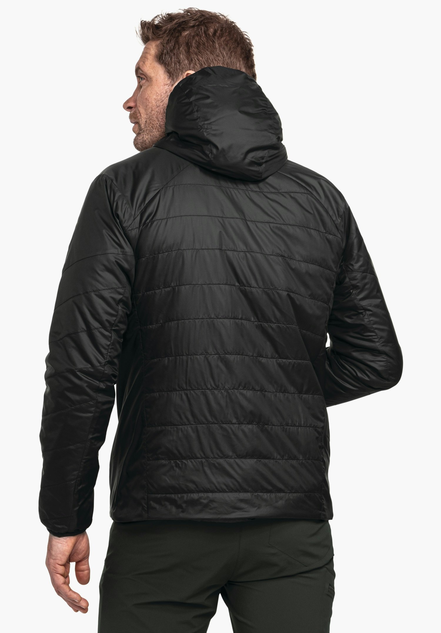 Ins Jacket Style Cascata MNS man wearing a black quilted hooded jacket; standing with his back to the camera and looking slightly left; white background.