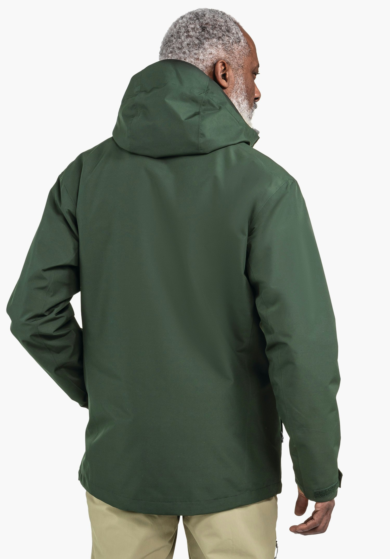 3in1 Jacket Style Okere MNS dunkelgrüne Jacke, getragen von einer Person, steht mit dem Rücken zur Kamera und dreht den Kopf nach rechts; neutraler heller Hintergrund.