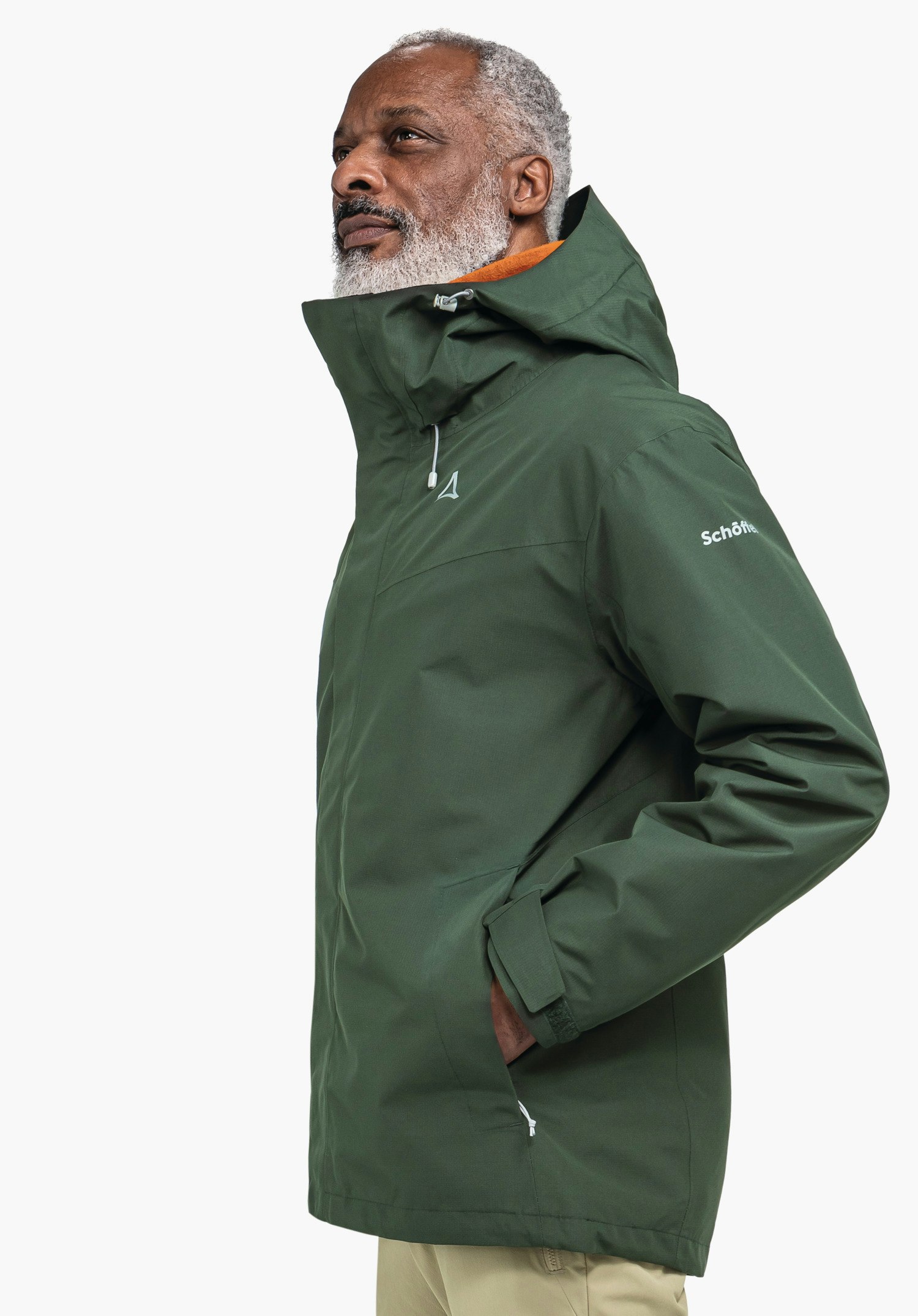 3in1 Jacket Style Okere MNS dunkelgrüne Kapuzenjacke, Kapuze hochgezogen; Person schaut nach oben; seitliche Aufnahme vor weißem Hintergrund. Schöffel-Logo auf Brust; Schriftzug "Schöffel" auf Ärmel.